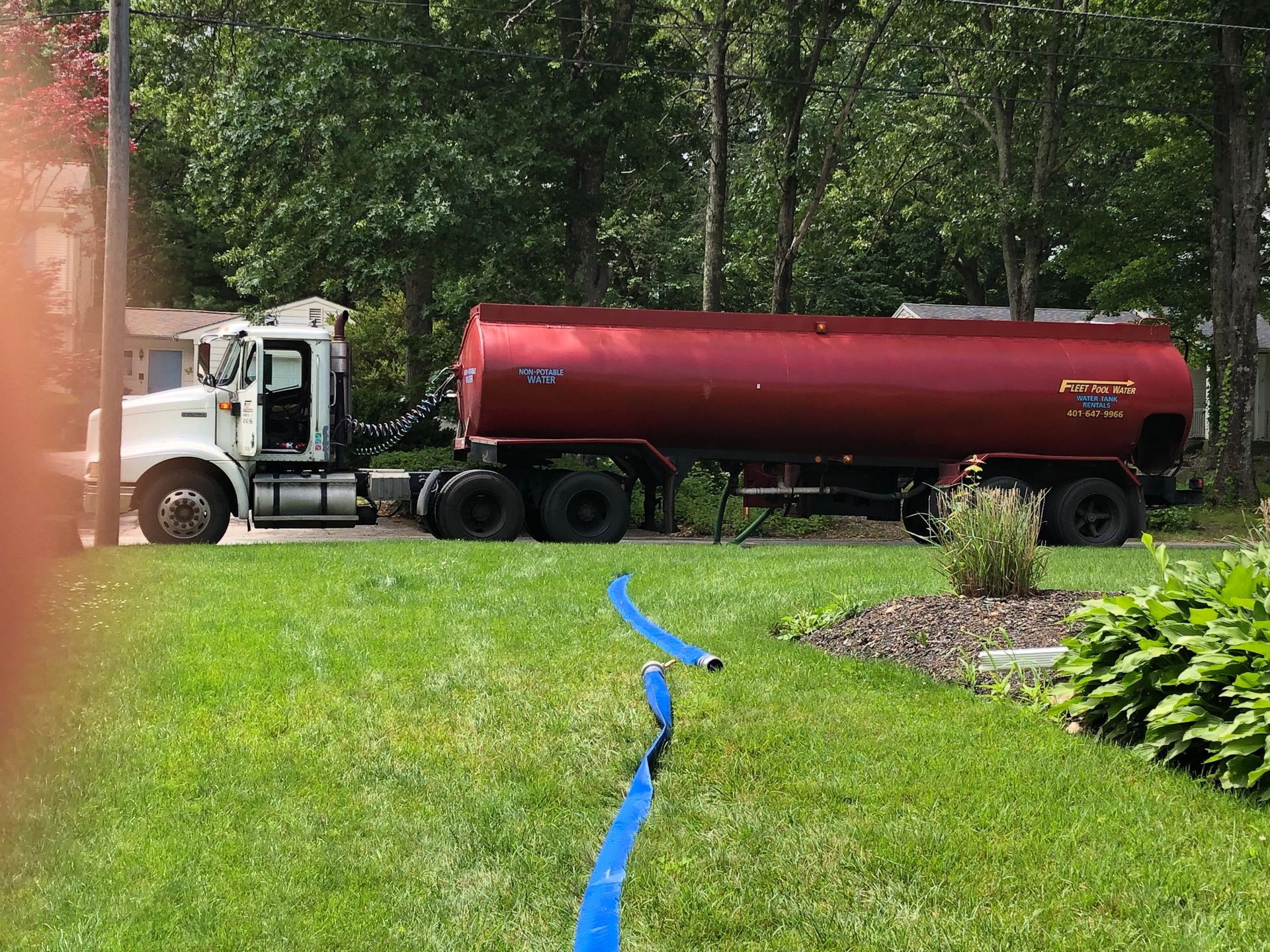 Fleet Water Delivery red truck with a blue hose