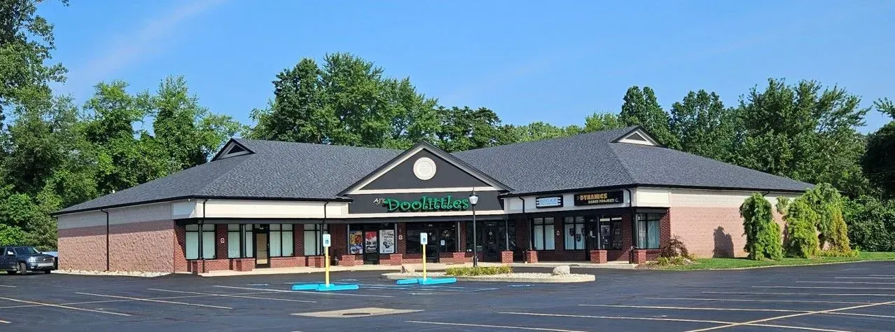 Building with a brick facade, gray roof, and a sign that reads 
