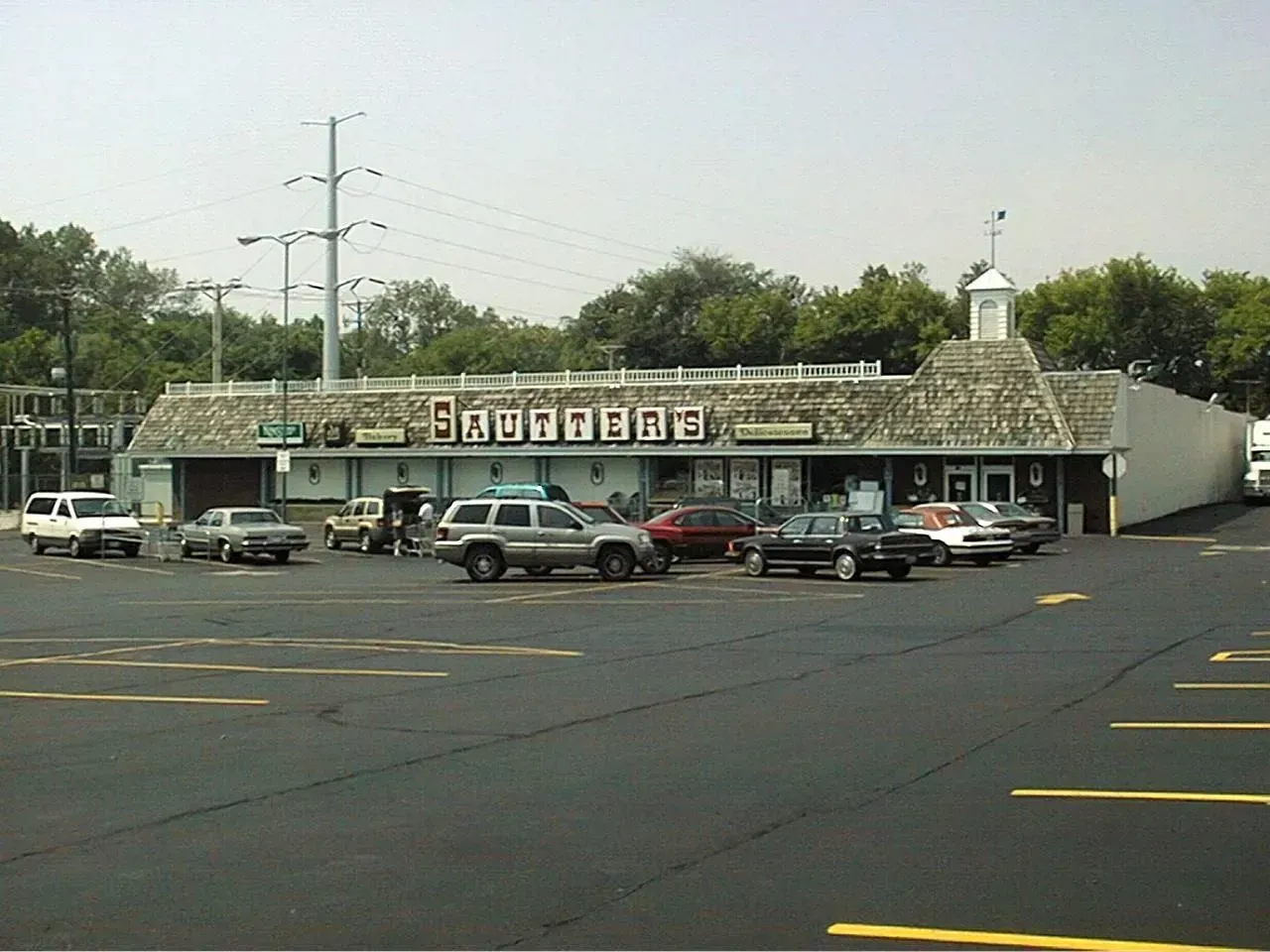 Exterior view of a shopping center with a parking lot filled with cars. 
