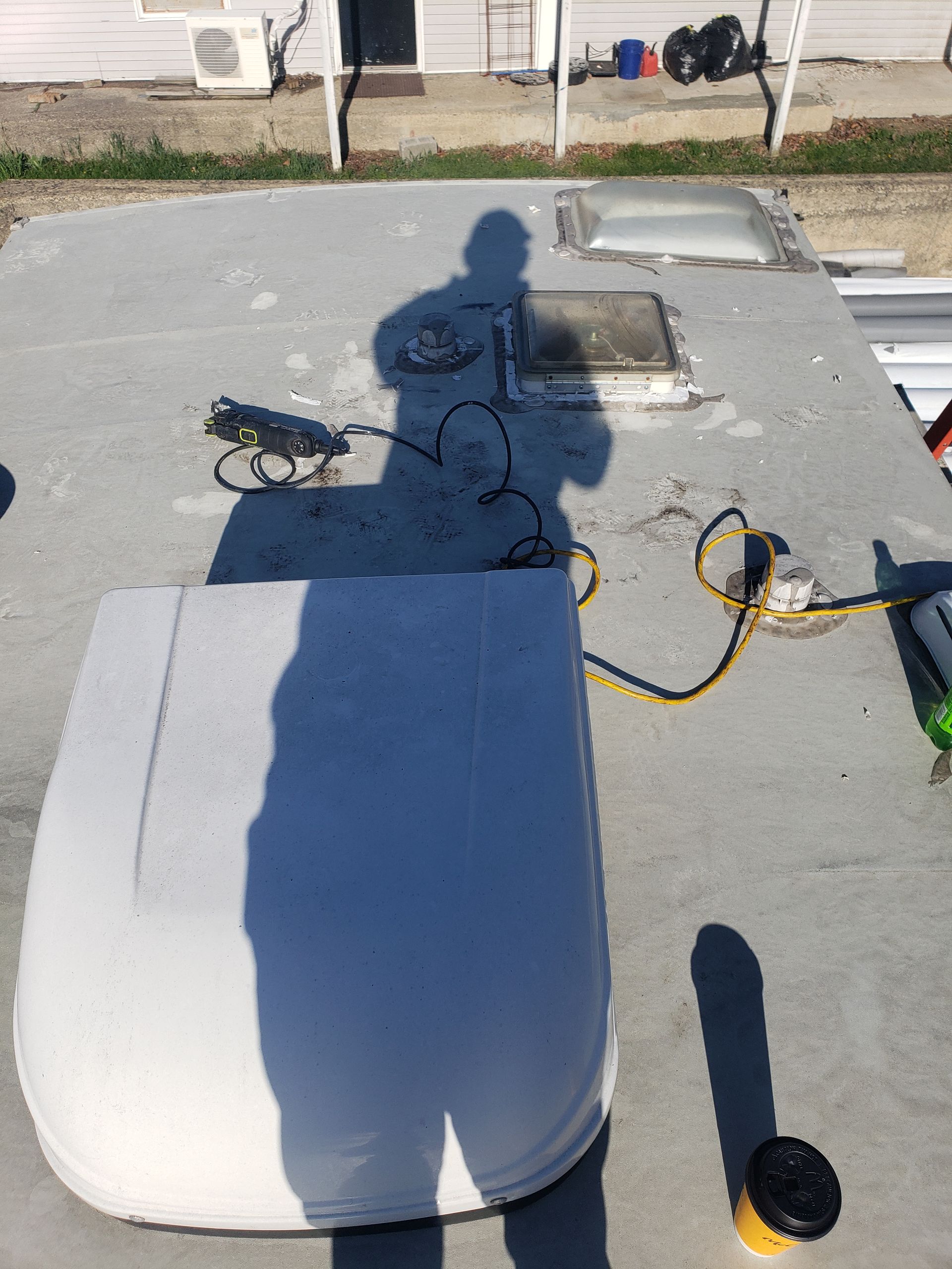 A shadow of a person is cast on the roof of a rv.