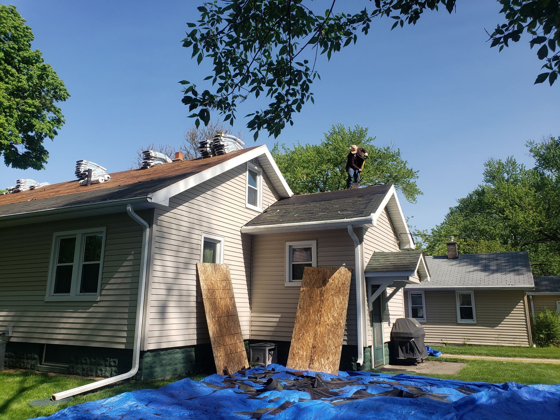 A man is working on the roof of a house.