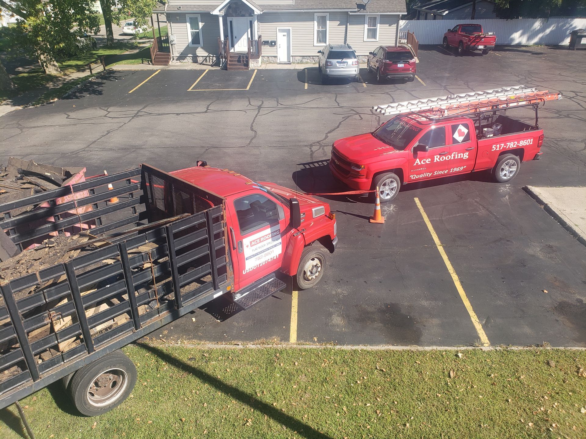Two red trucks are parked in a parking lot