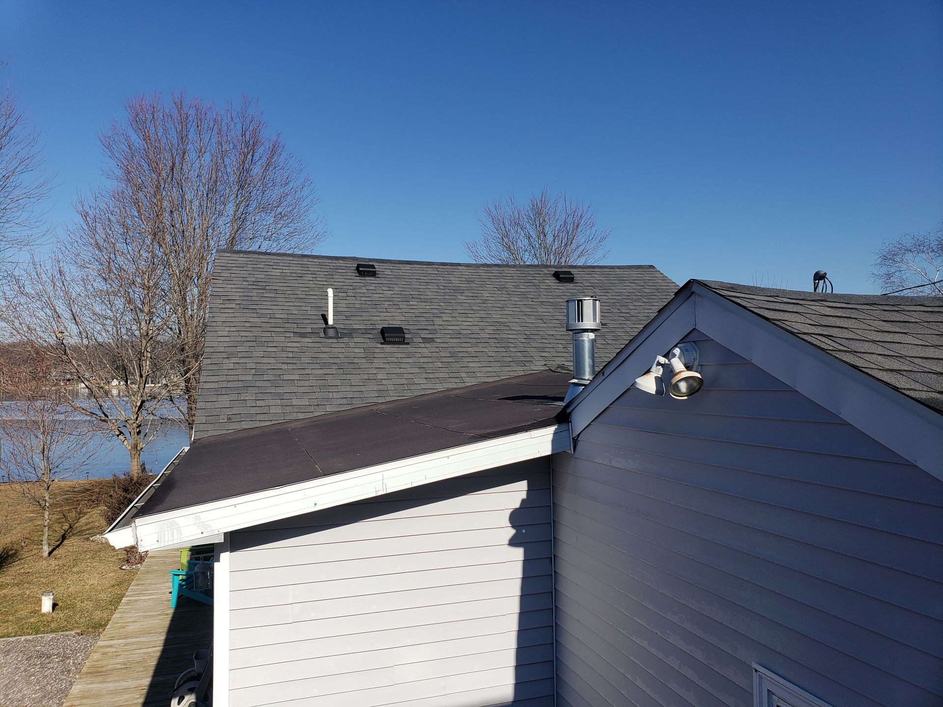 A house with a roof that has a chimney on it.