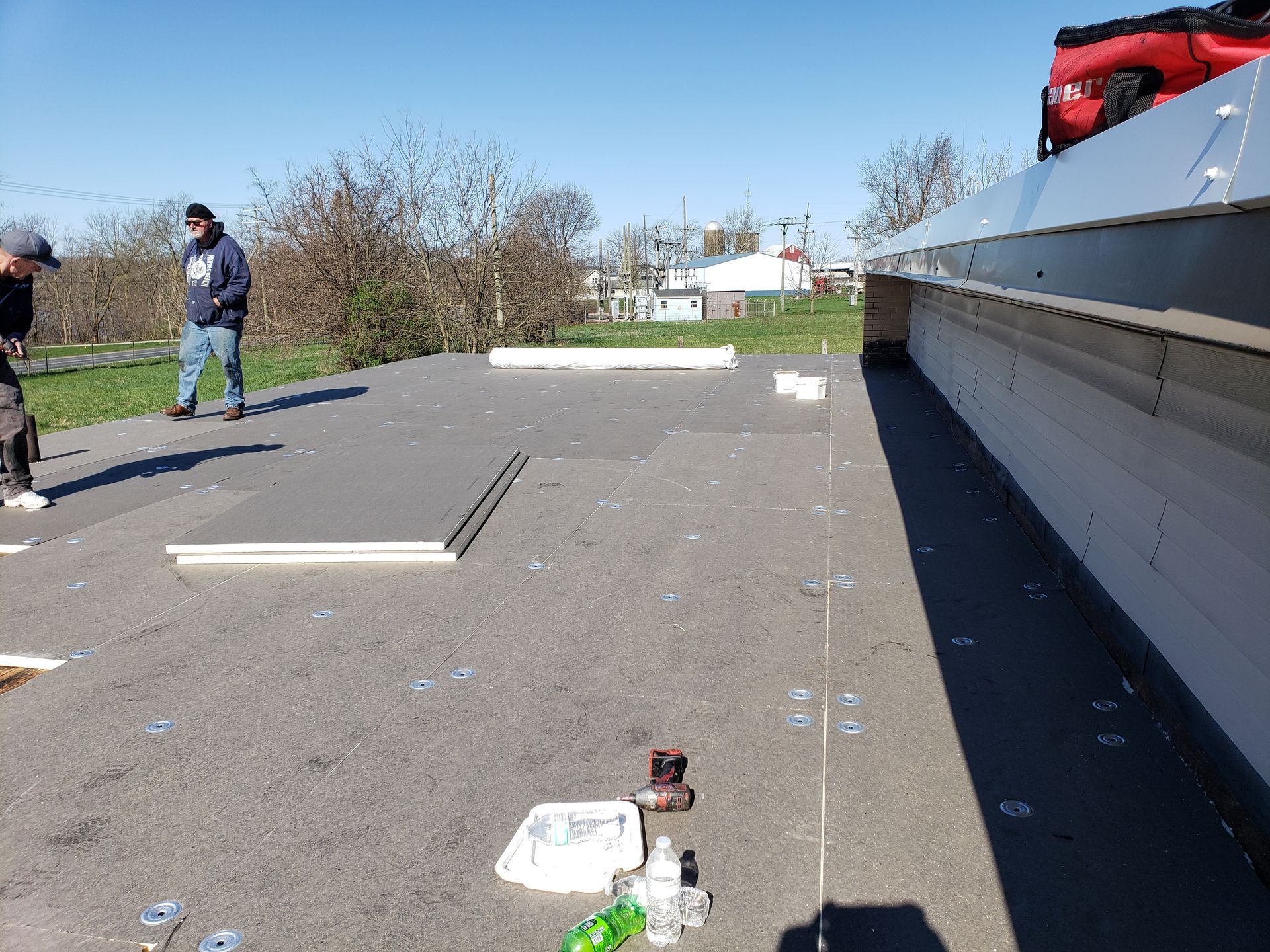 A group of men are standing on top of a roof.