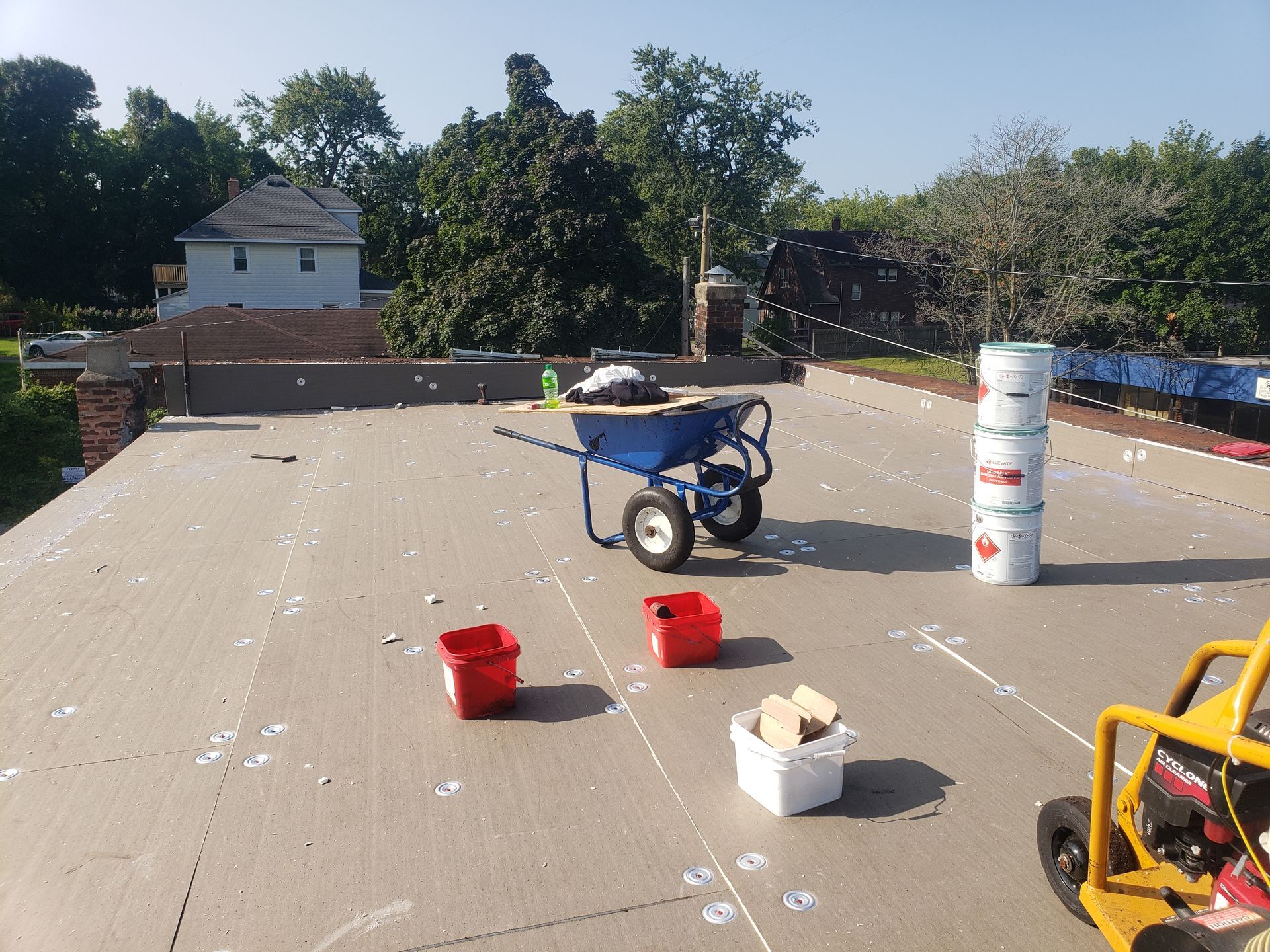 A wheelbarrow is sitting on the roof of a building.