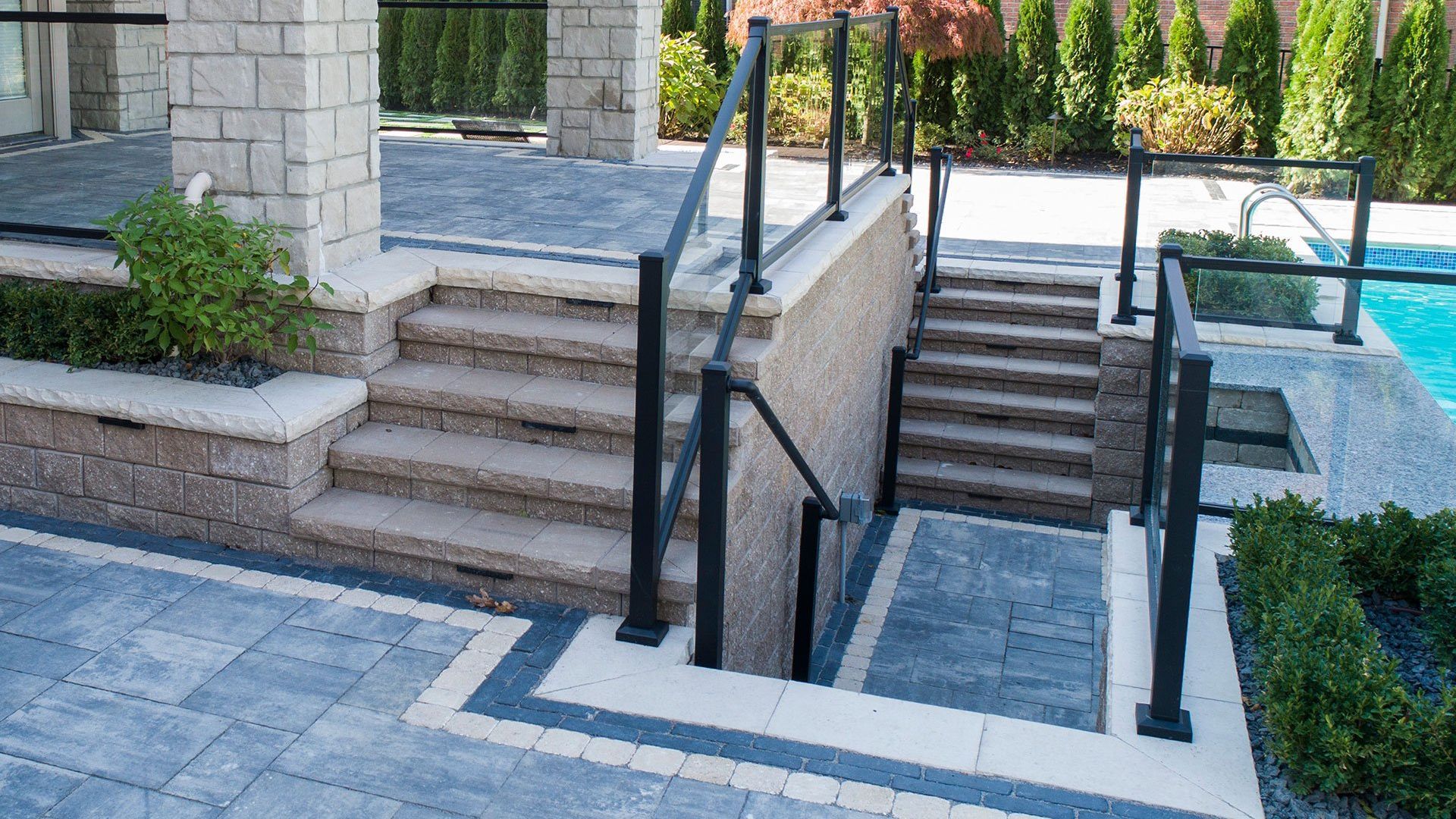 a set of stairs leading up to a pool with a railing .