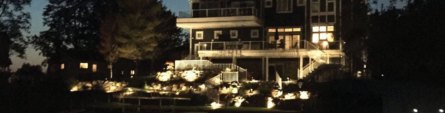 a large house with a lot of windows is lit up at night