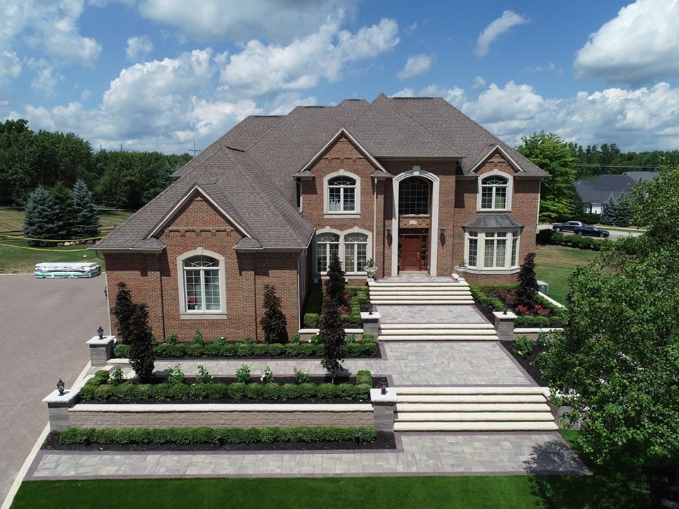 An aerial view of a large brick house with stairs leading up to it