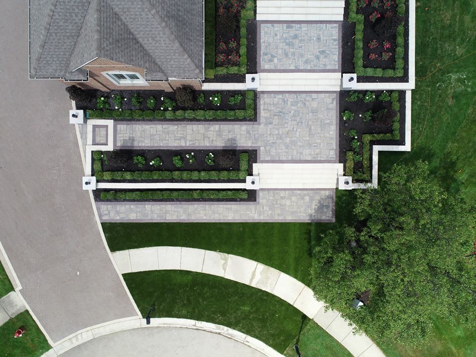 An aerial view of a house with a driveway and lawn.