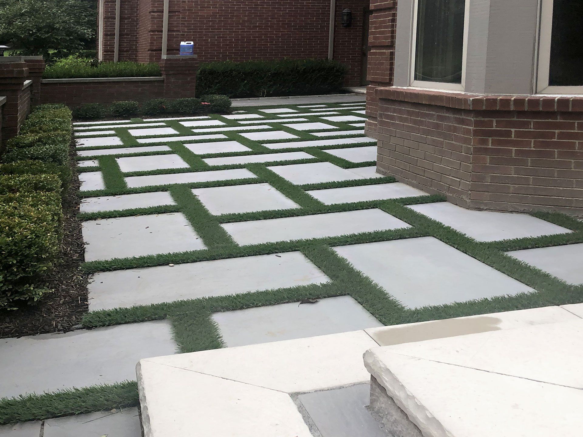 A brick building with a walkway surrounded by grass