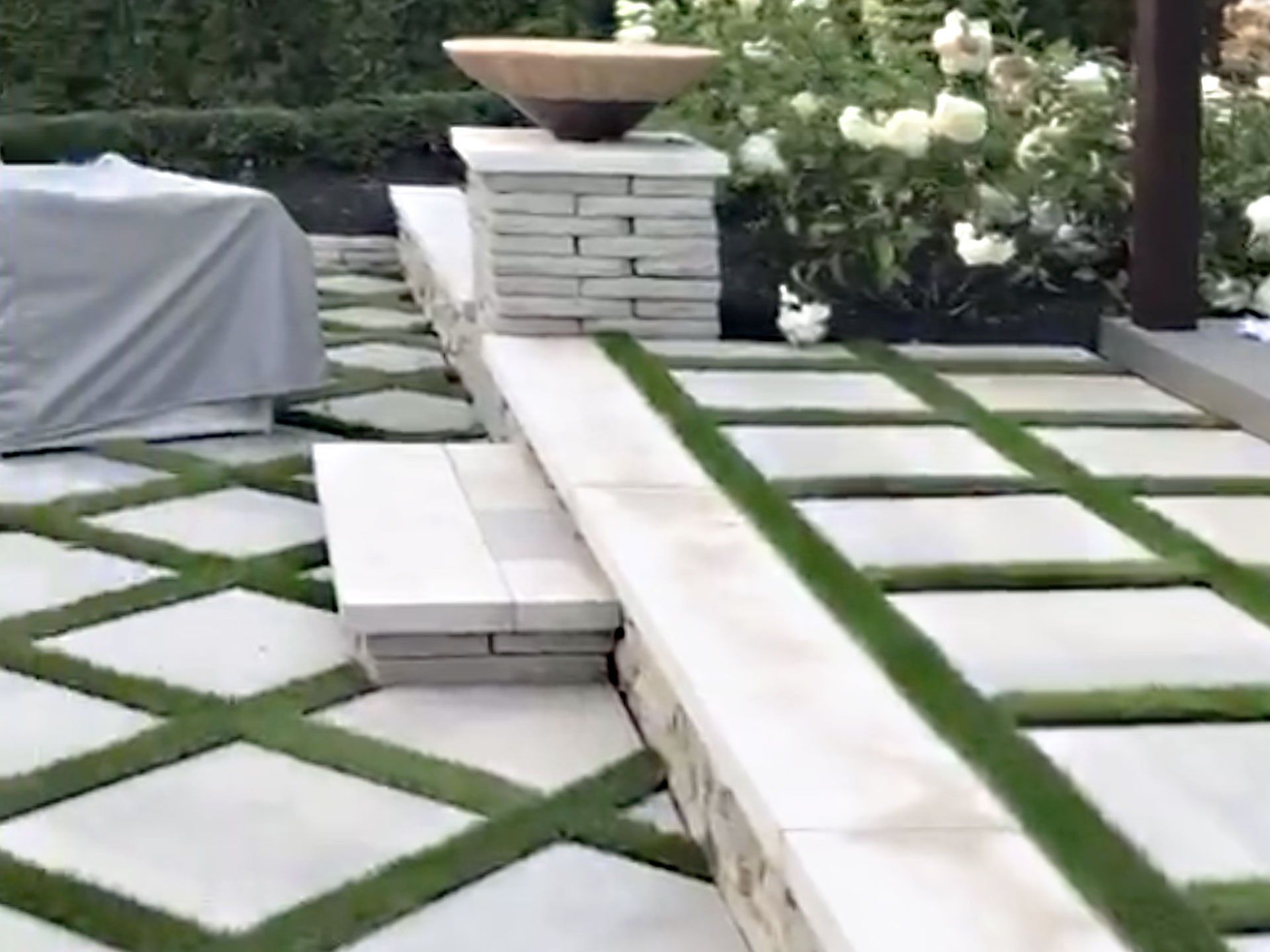 A patio with a brick walkway and a lawn.