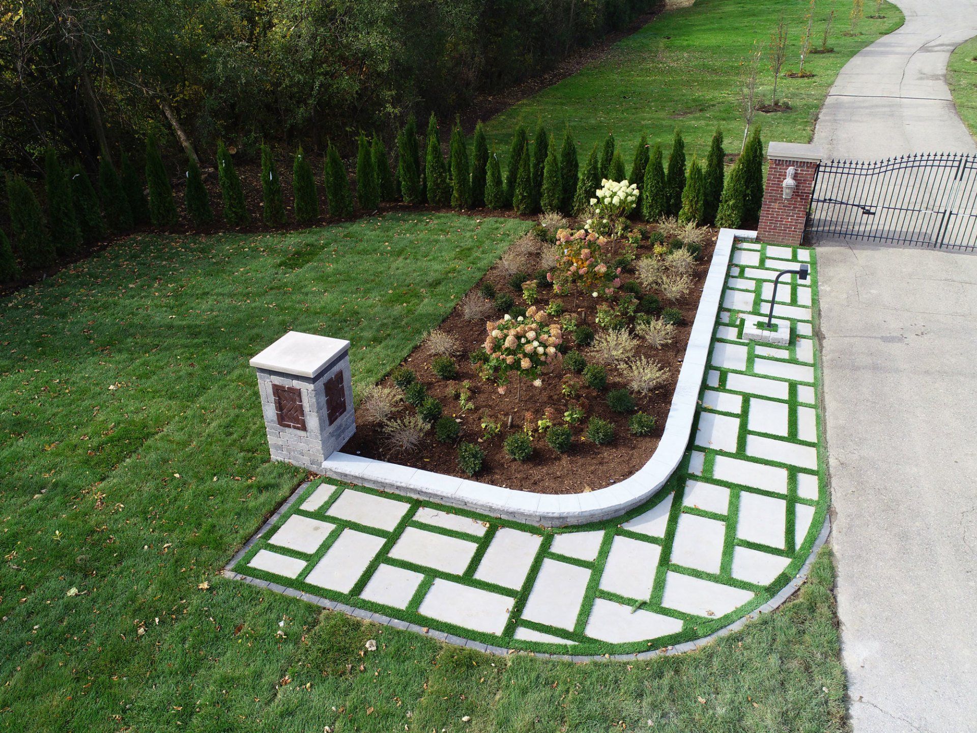 A brick walkway leading to a lush green lawn.