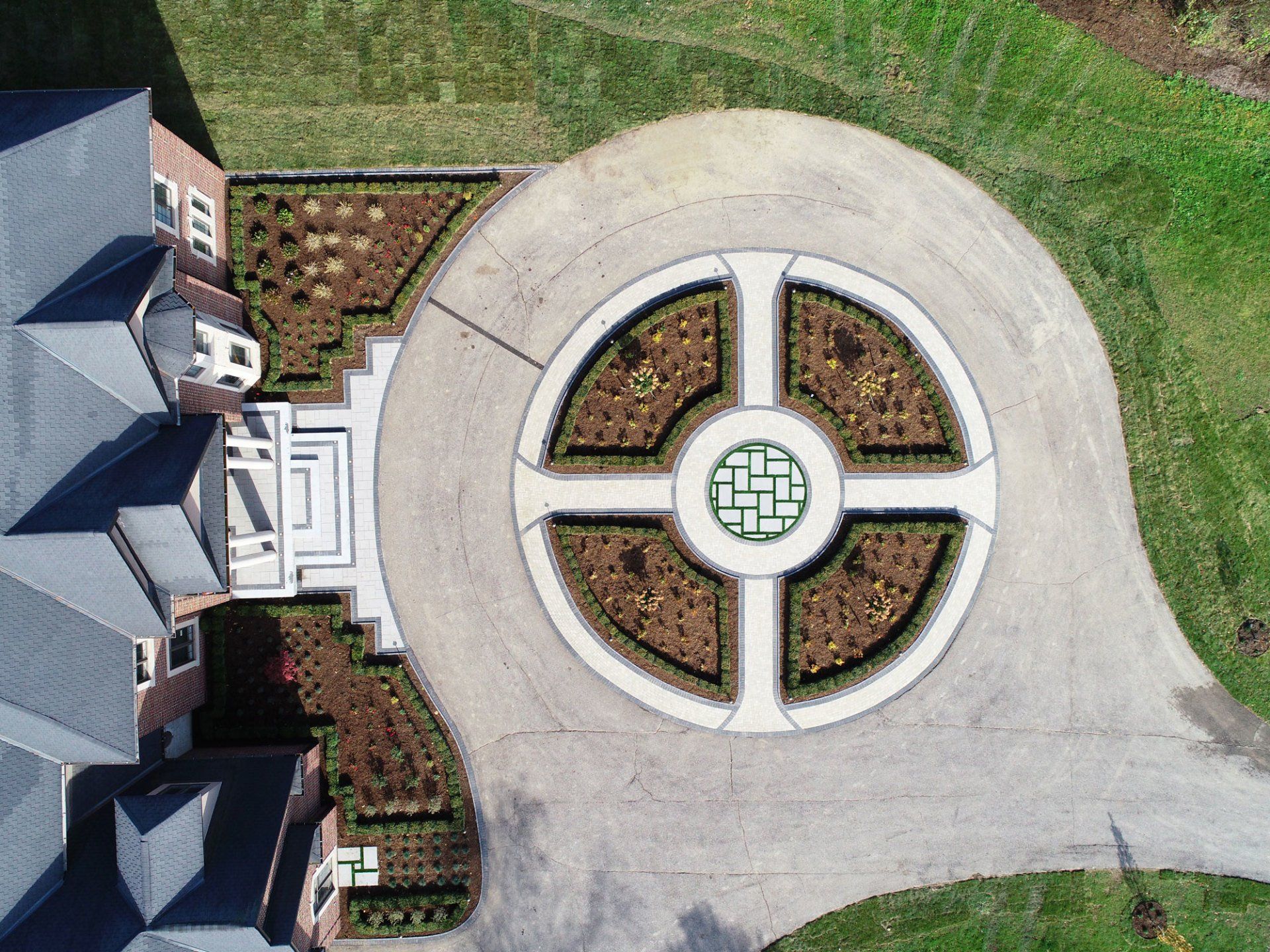 An aerial view of a driveway with a circular design in the middle