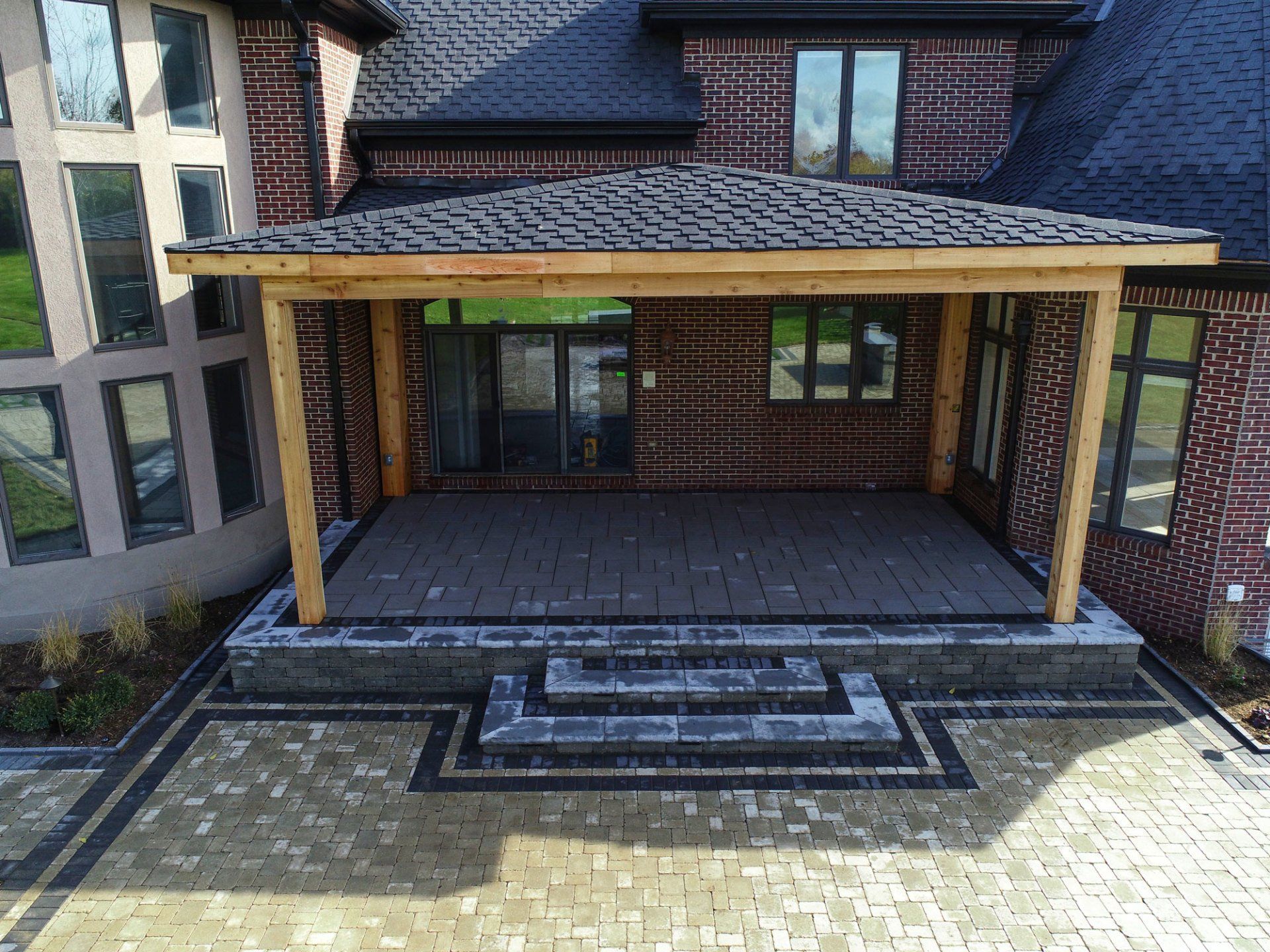 An aerial view of a brick house with a wooden porch.