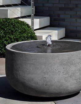 a large concrete bowl with a fountain inside of it .