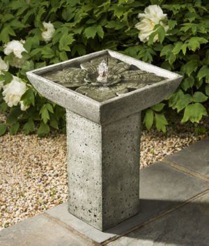 a bird bath with a fountain in the middle of it
