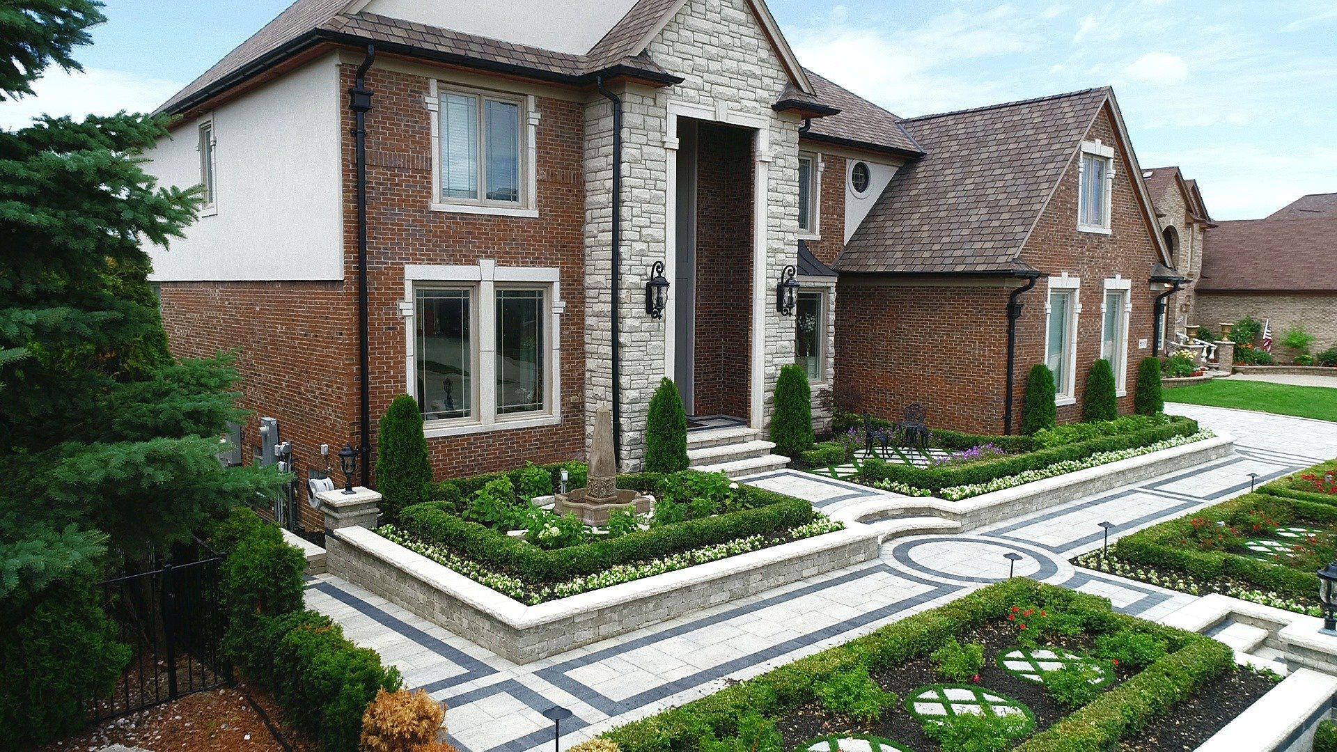 A large brick house with a lush green lawn in front of it