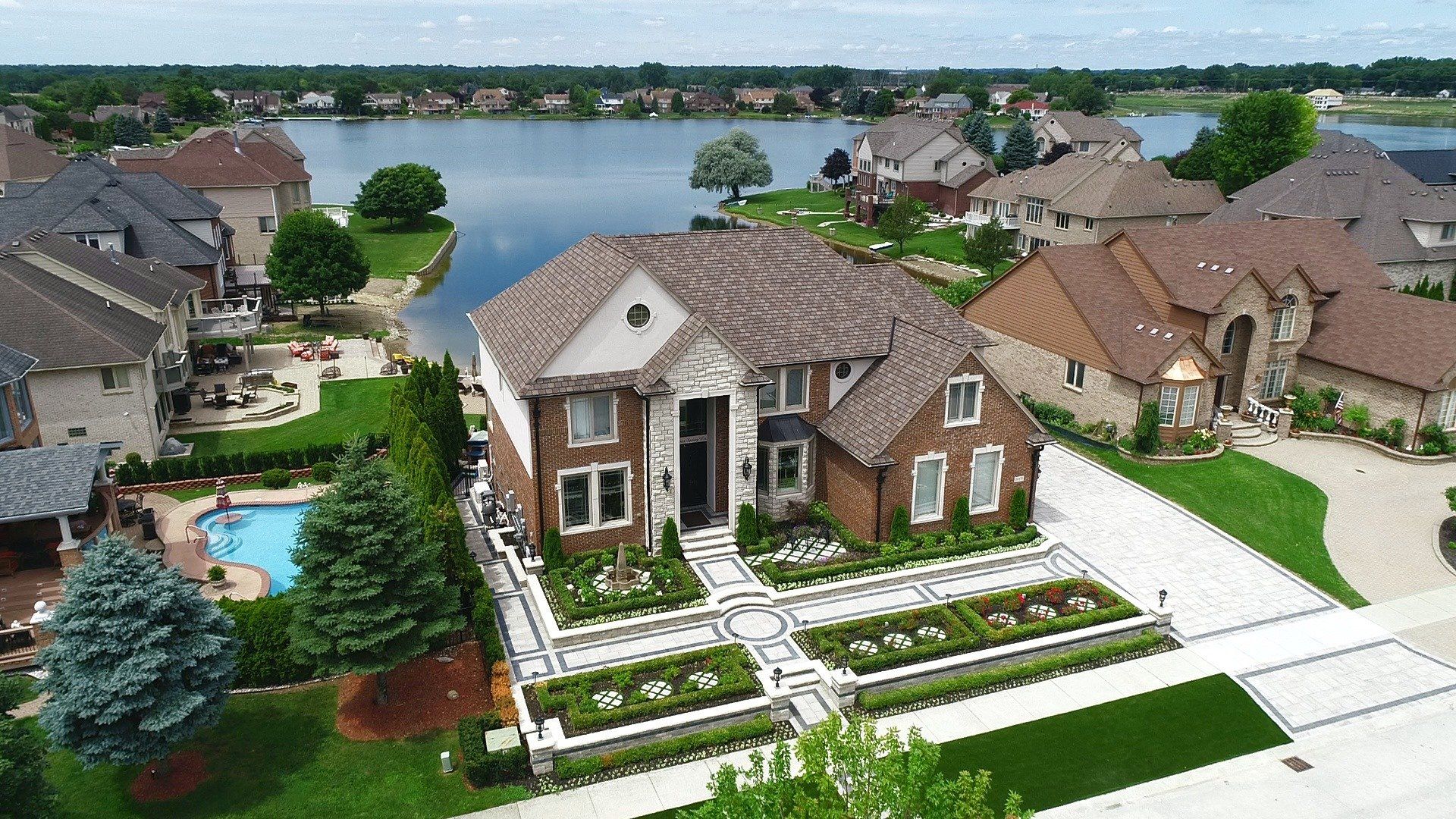 An aerial view of a residential area with a large house and a pool.