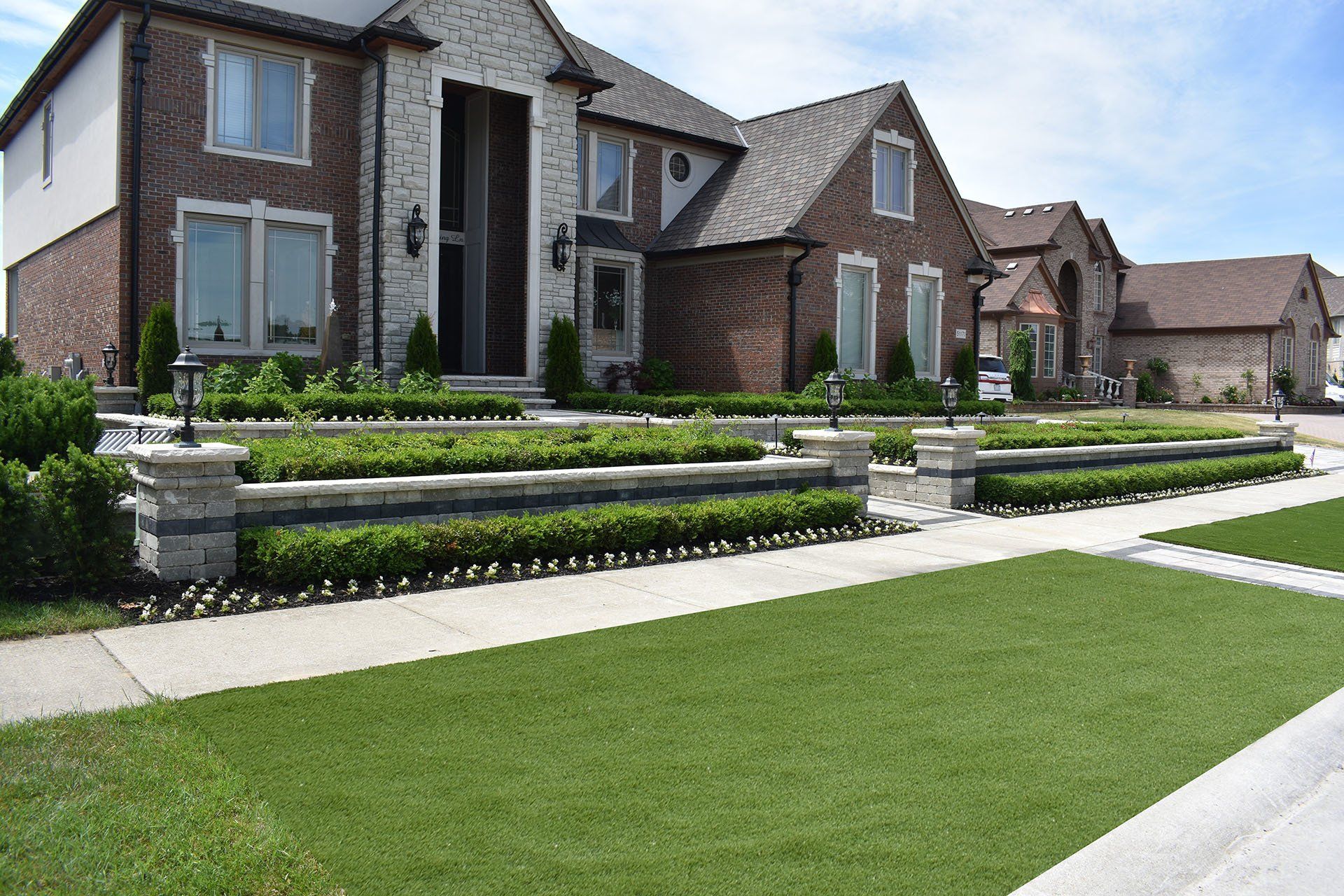 A large brick house with a lush green lawn in front of it