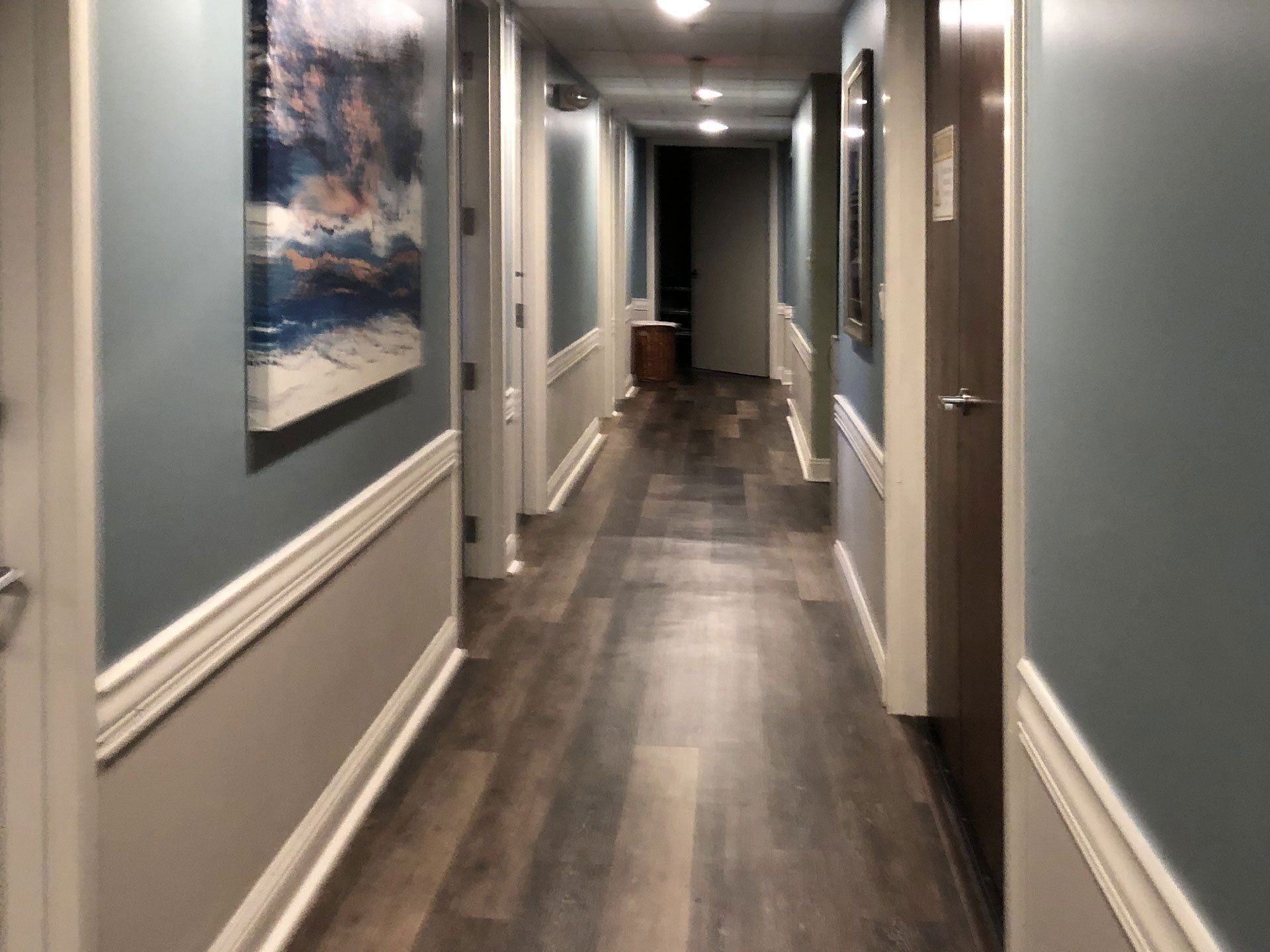A long hallway with a painting on the wall
