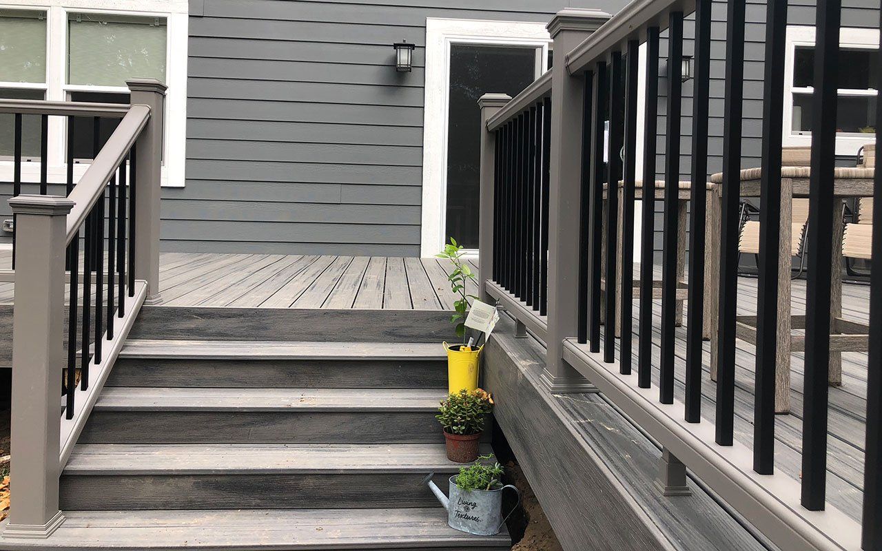 a deck with stairs leading up to it and a black railing .