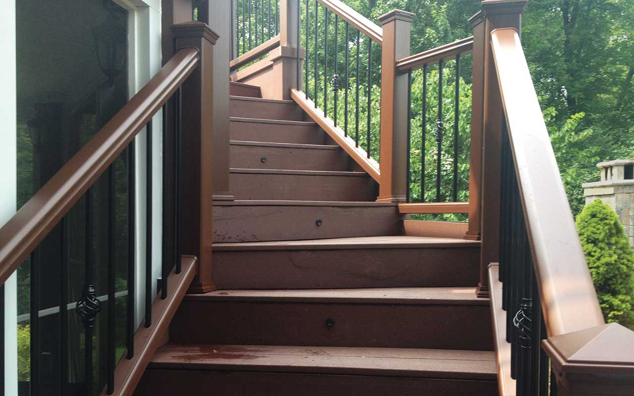 a wooden deck with stairs and a metal railing