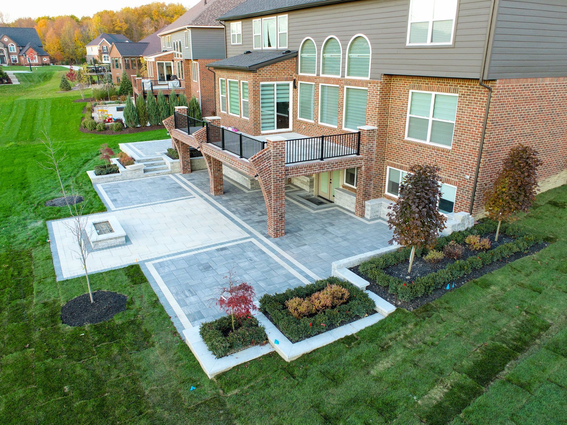 an aerial view of a large brick house with a large patio in front of it .