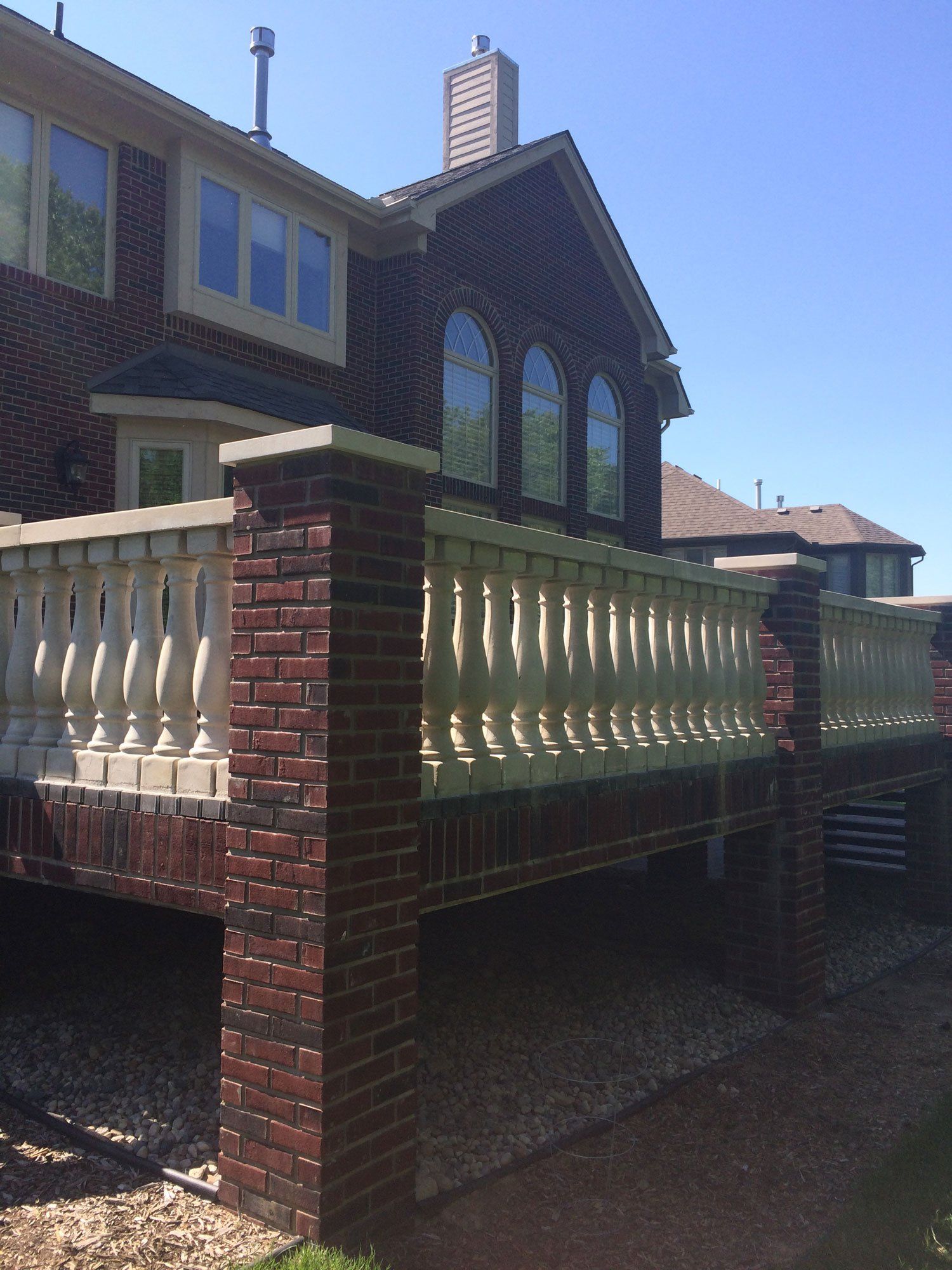 a brick house with a white railing on the side