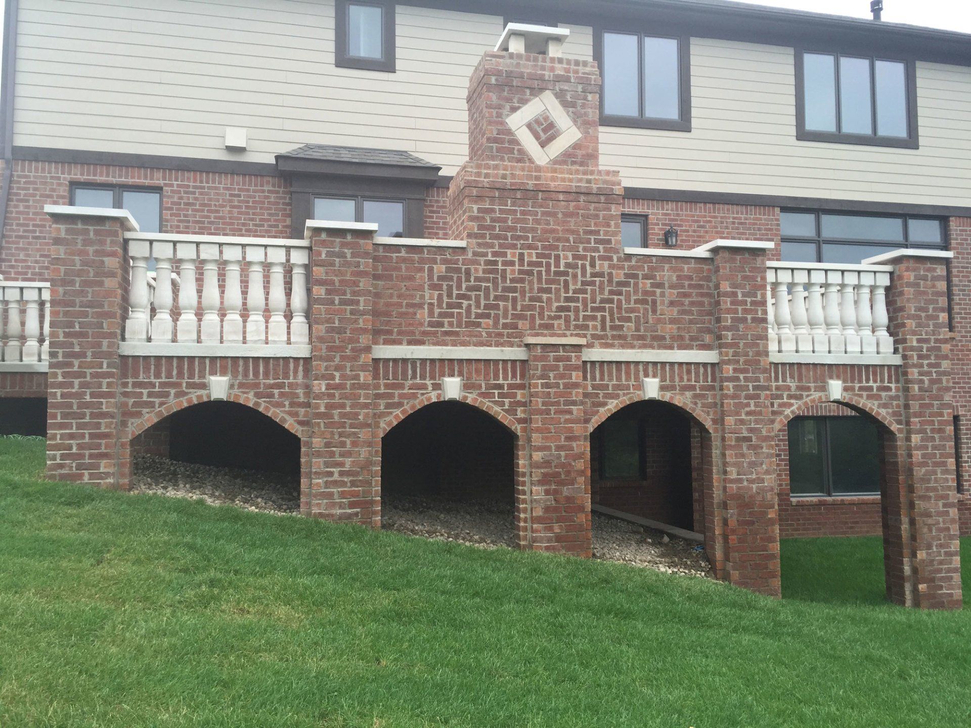 a brick house with a balcony and a fireplace