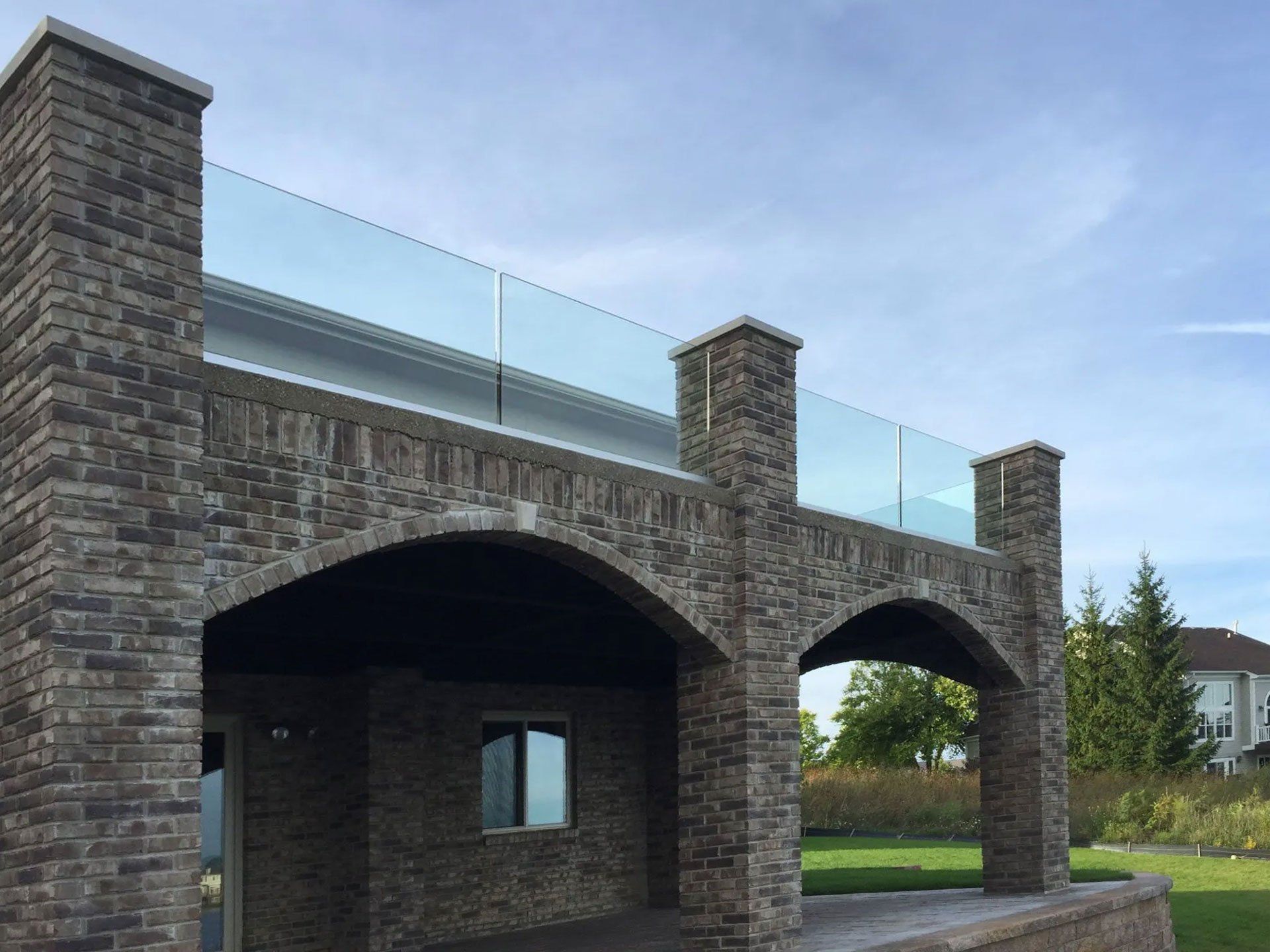 a brick building with arches and a glass railing