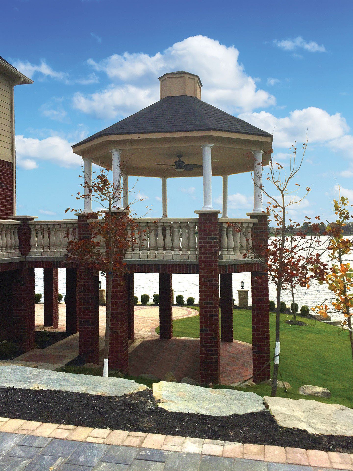 a gazebo is surrounded by brick pillars in a park
