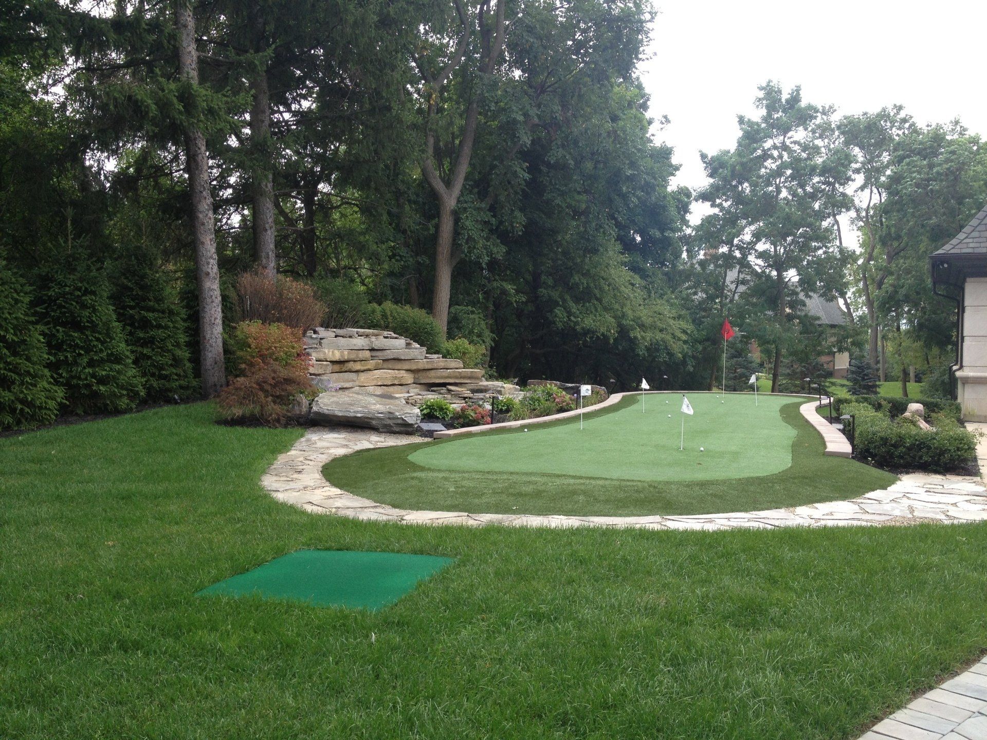 A lush green lawn with a putting green in the middle