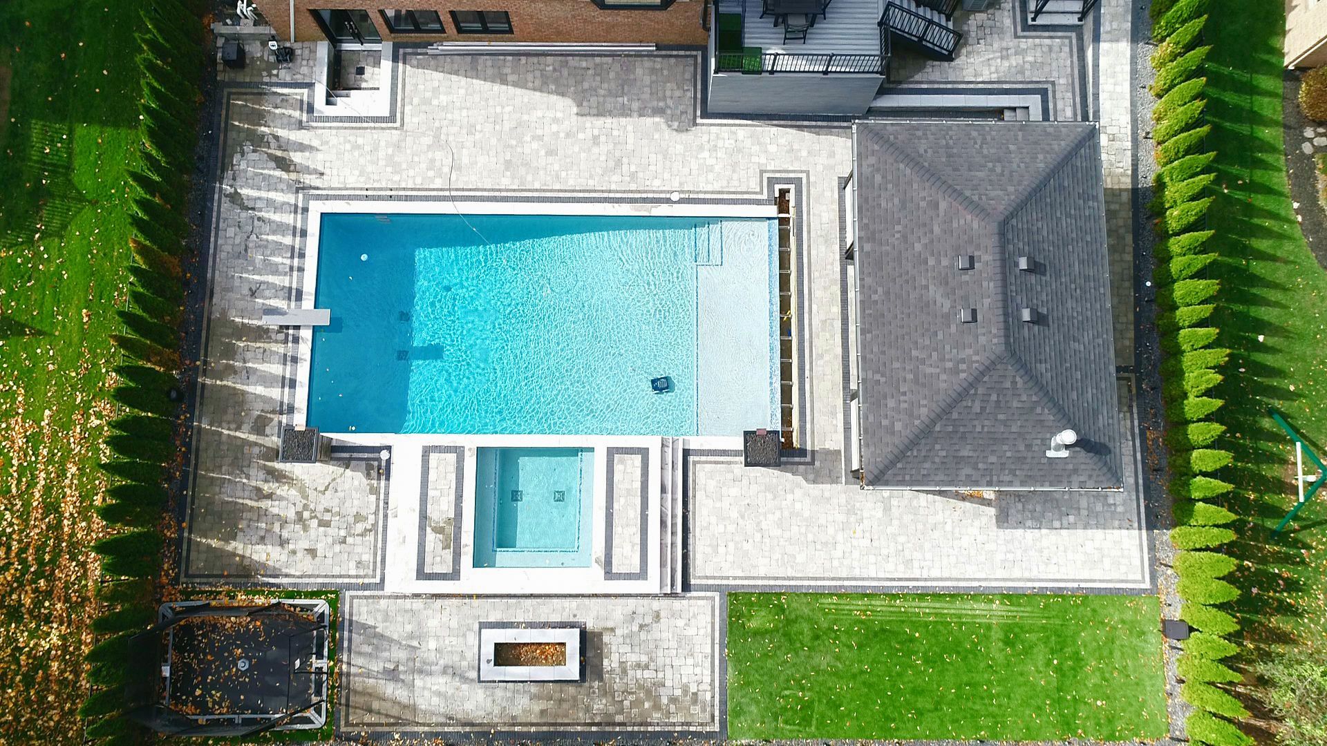 an aerial view of a large swimming pool in the backyard of a house .