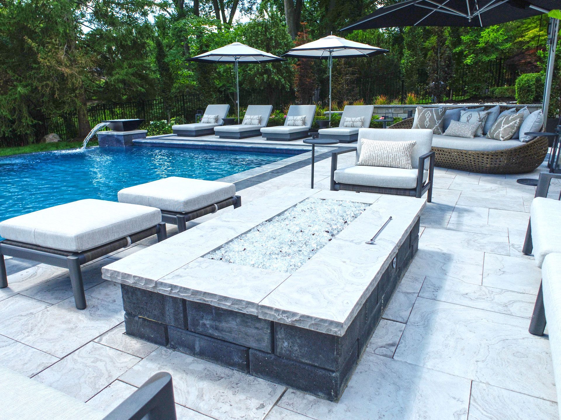 there is a fire pit in the middle of the patio next to the pool .