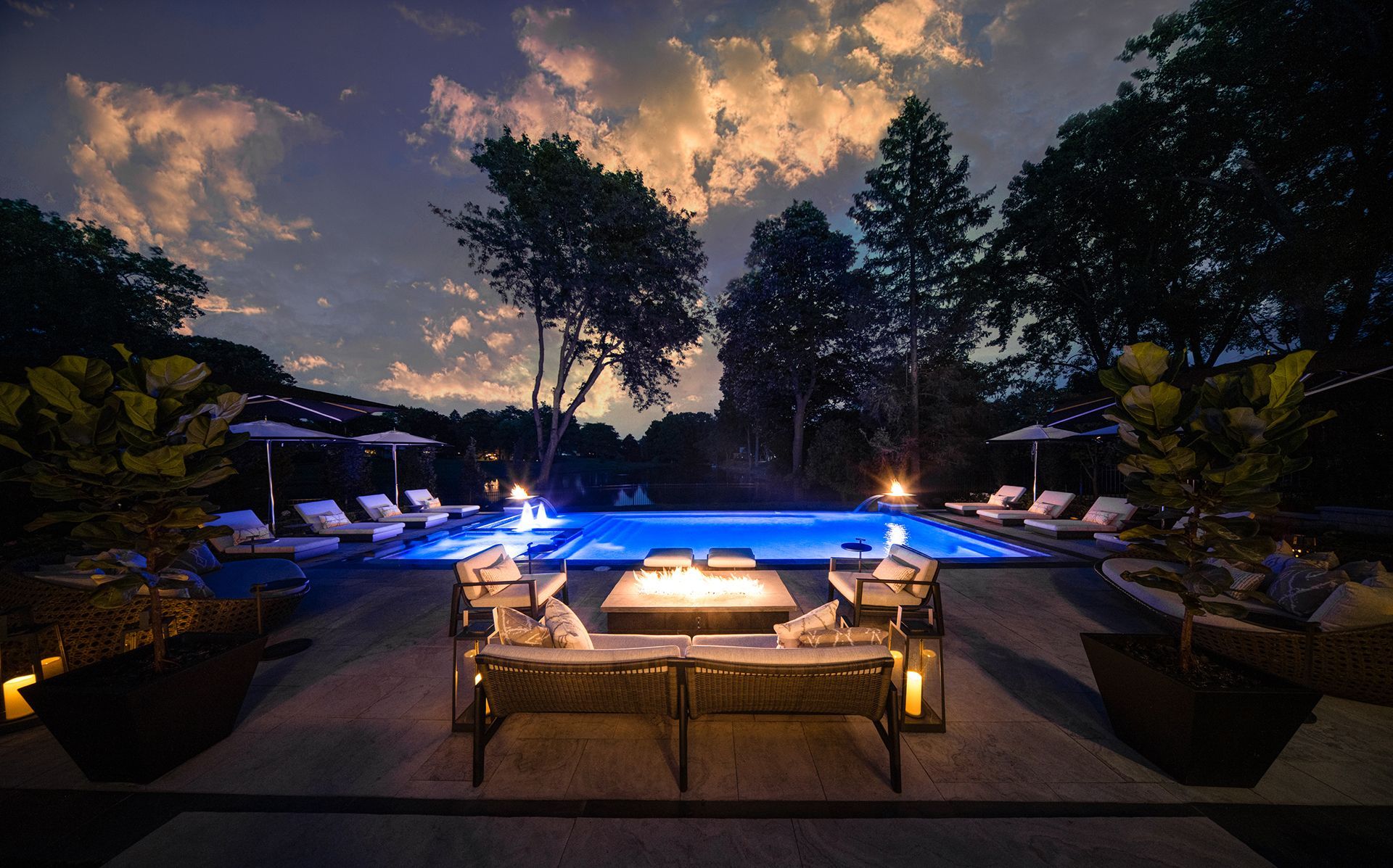 a large swimming pool with a fire pit in front of it