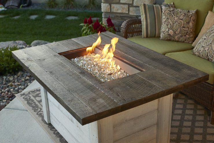a wooden table with a fire pit in the middle