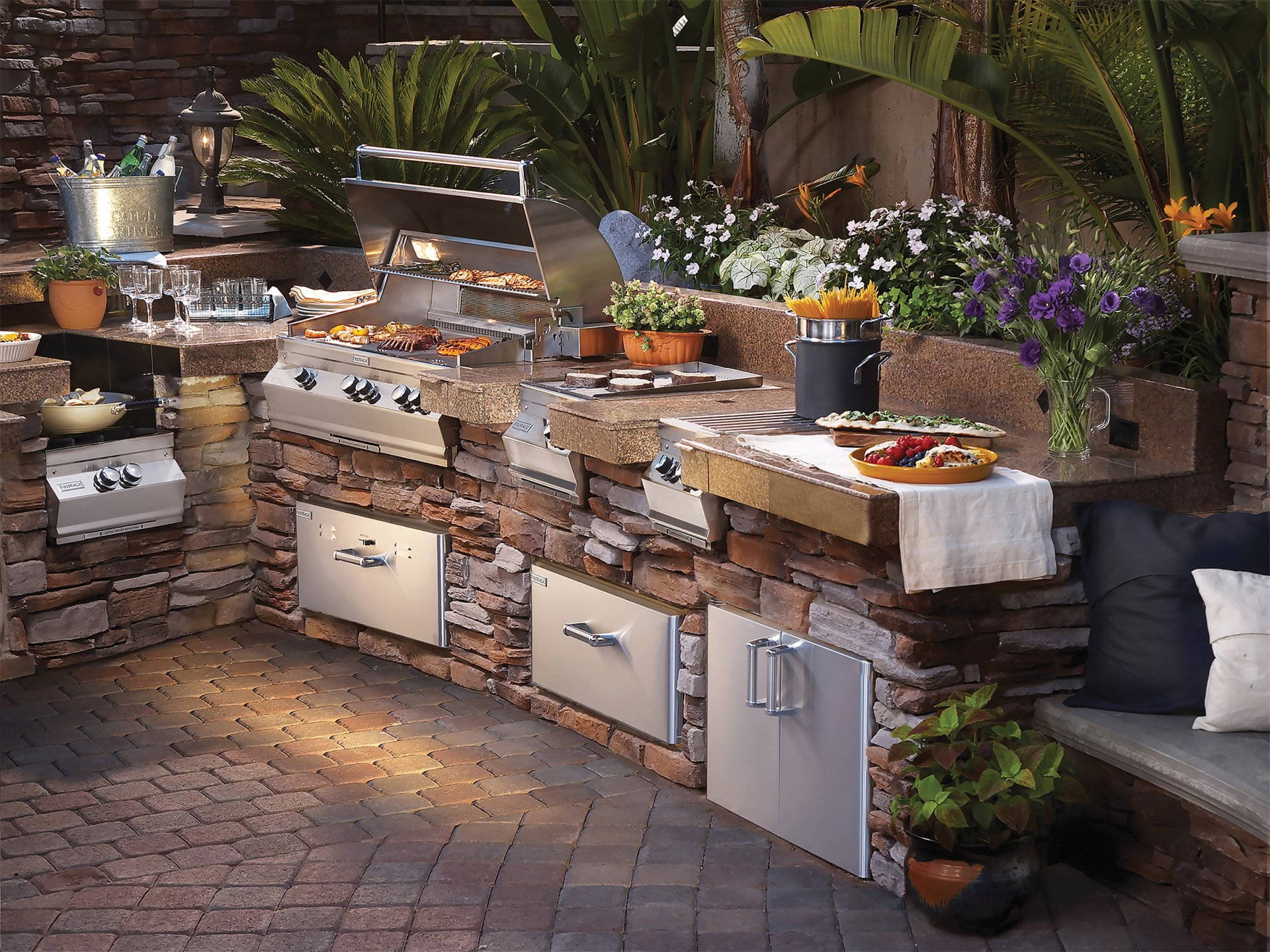 An outdoor kitchen with a lot of appliances and flowers
