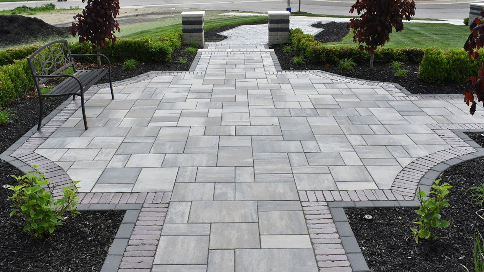 A brick walkway with a bench in the middle