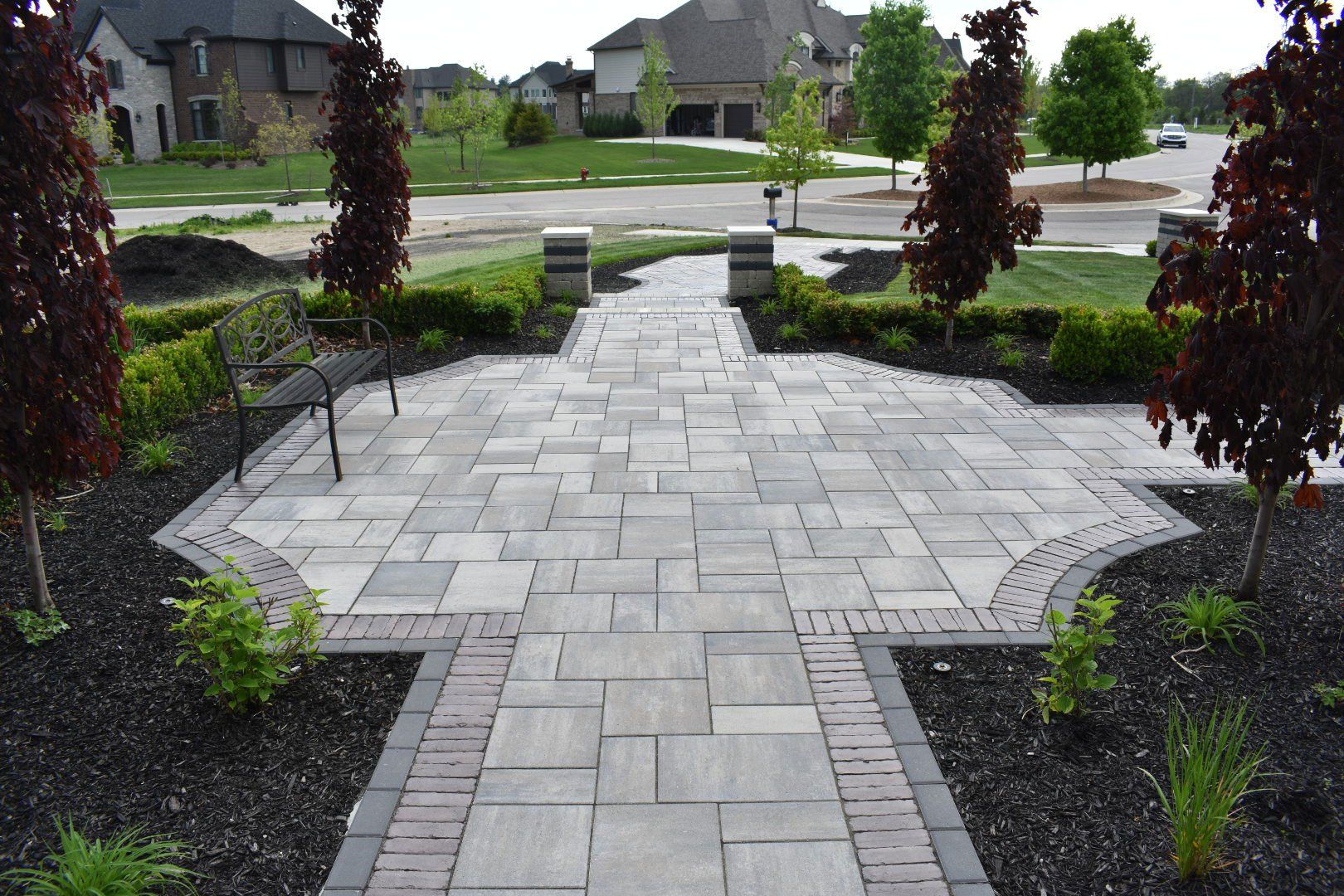 a brick walkway leading to a patio in a residential area