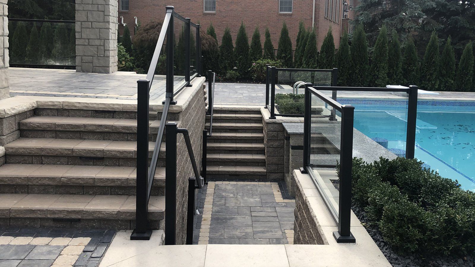 stairs leading up to a pool with a glass railing