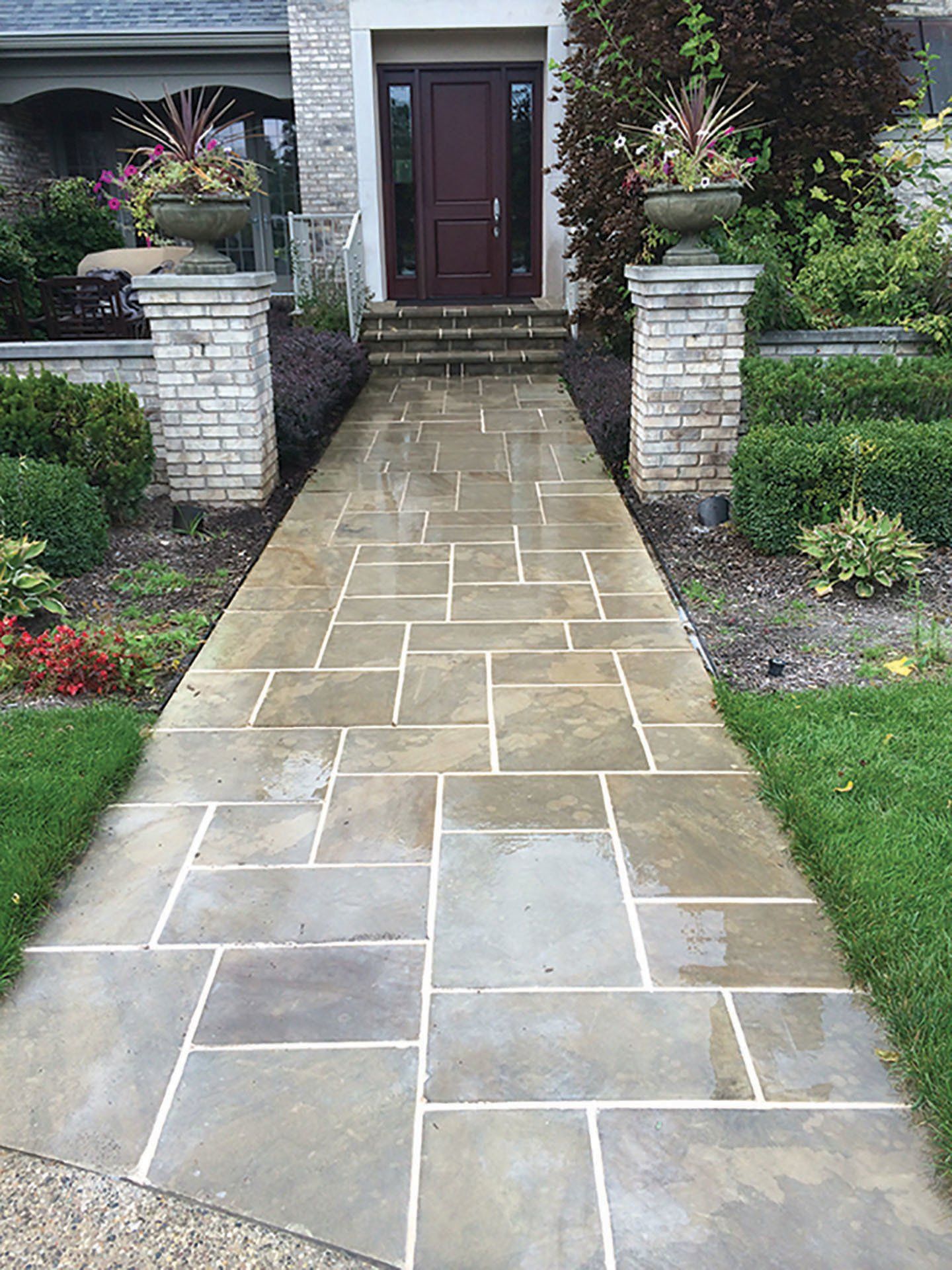 a stone walkway leading to the front door of a house .