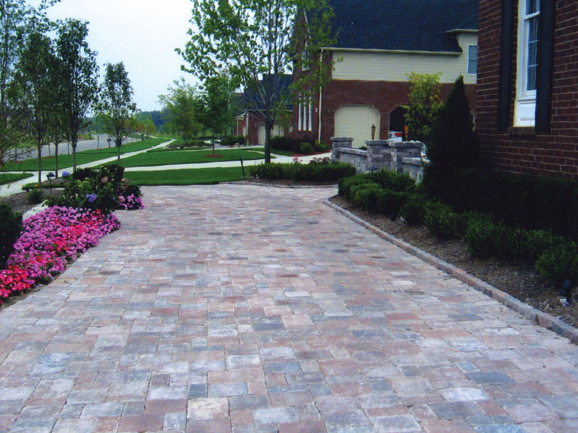 a brick driveway leading to a brick house