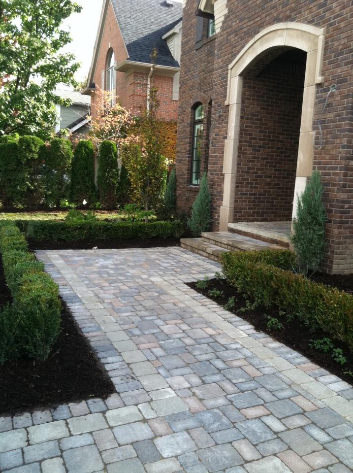 a brick house with a brick walkway leading to the front door .
