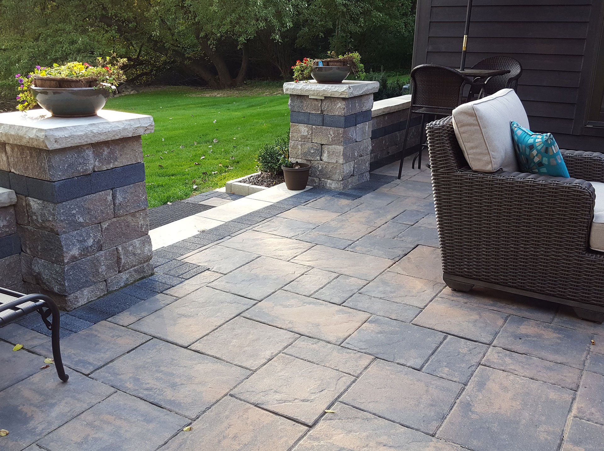 a patio with a chair , table , and potted plants .