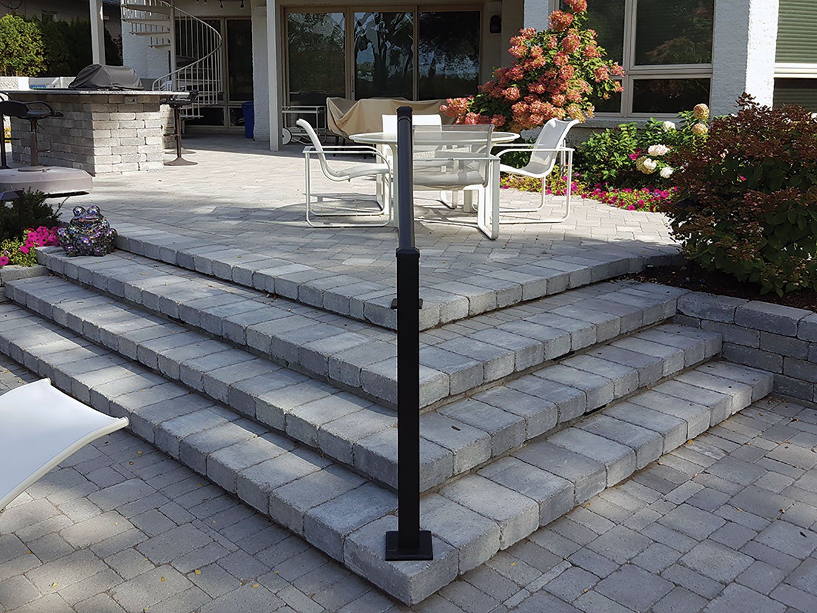 a set of stairs leading up to a patio with a table and chairs