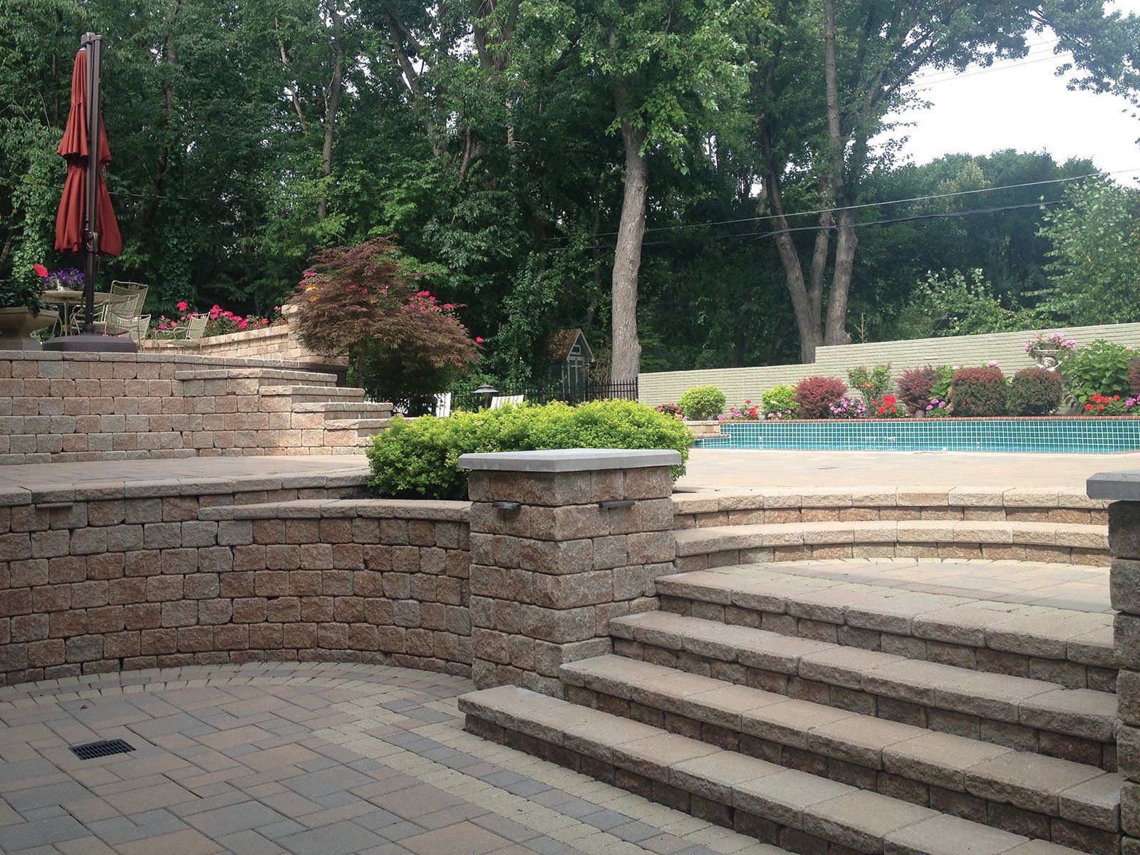 a patio with stairs and a pool in the background