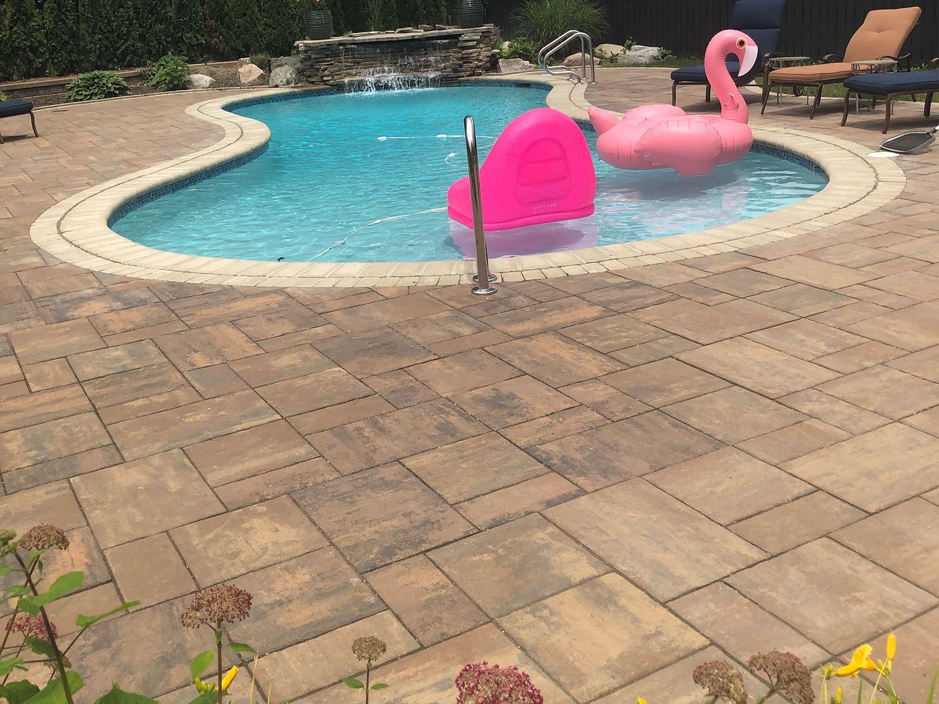 a pink flamingo float is floating in a swimming pool .