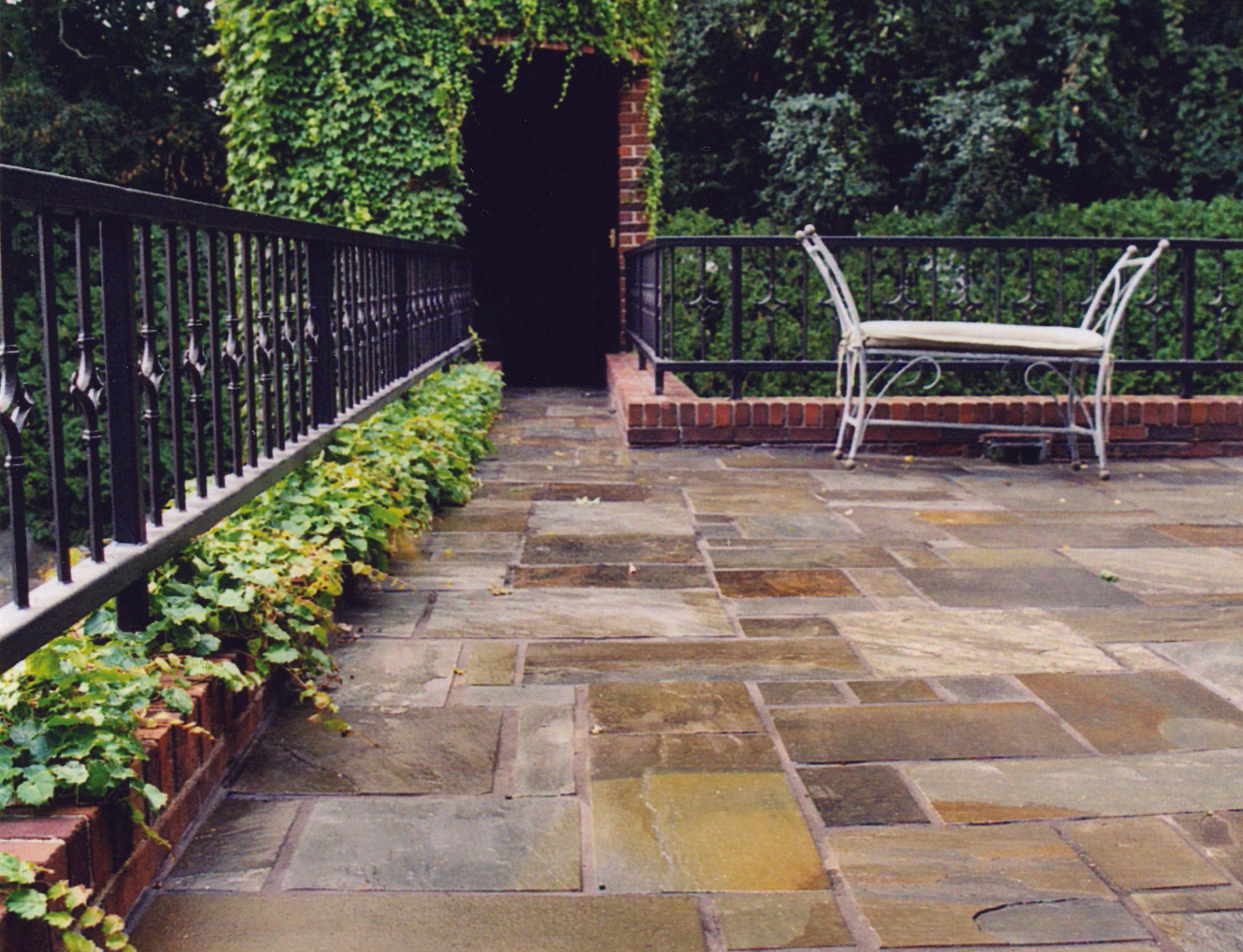 a patio with a bench and a fence in the background