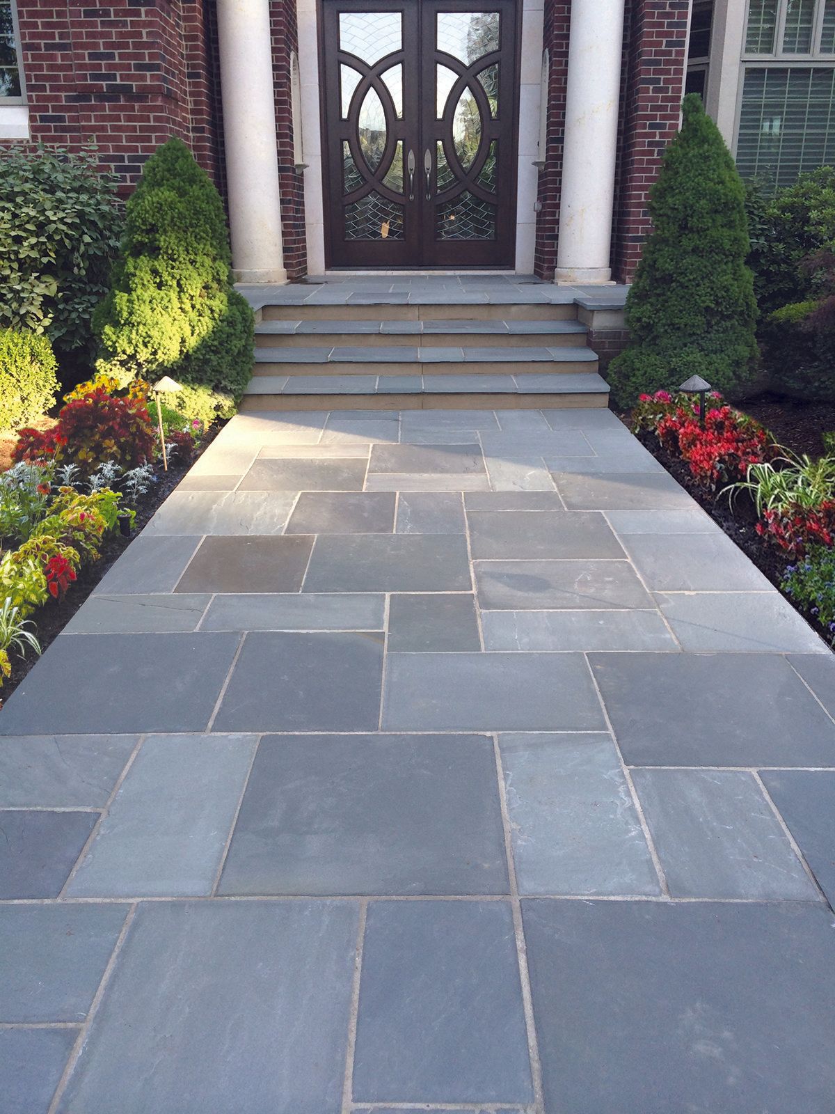 a stone walkway leading to the front door of a house .