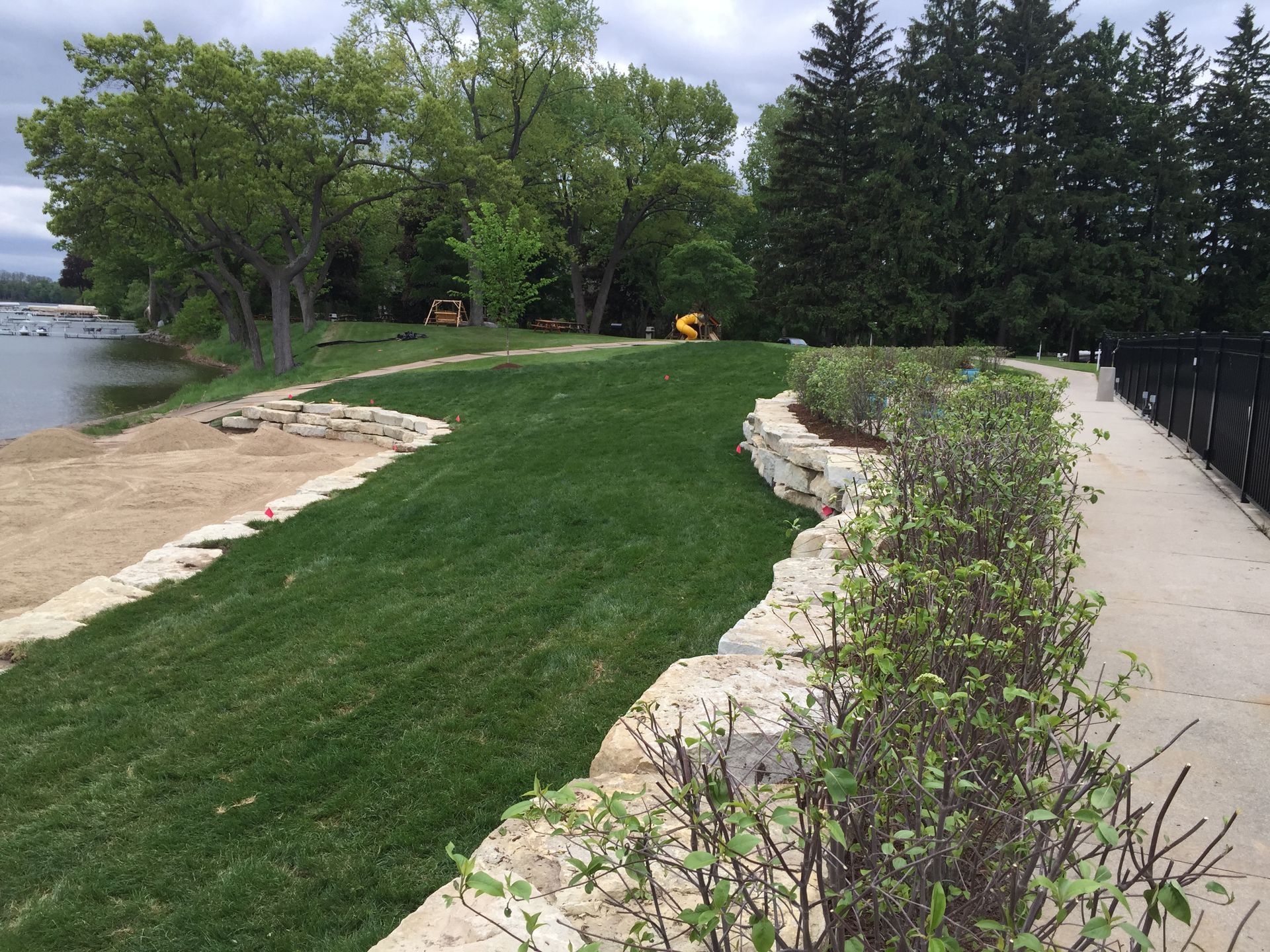 A path going through a grassy area next to a body of water.